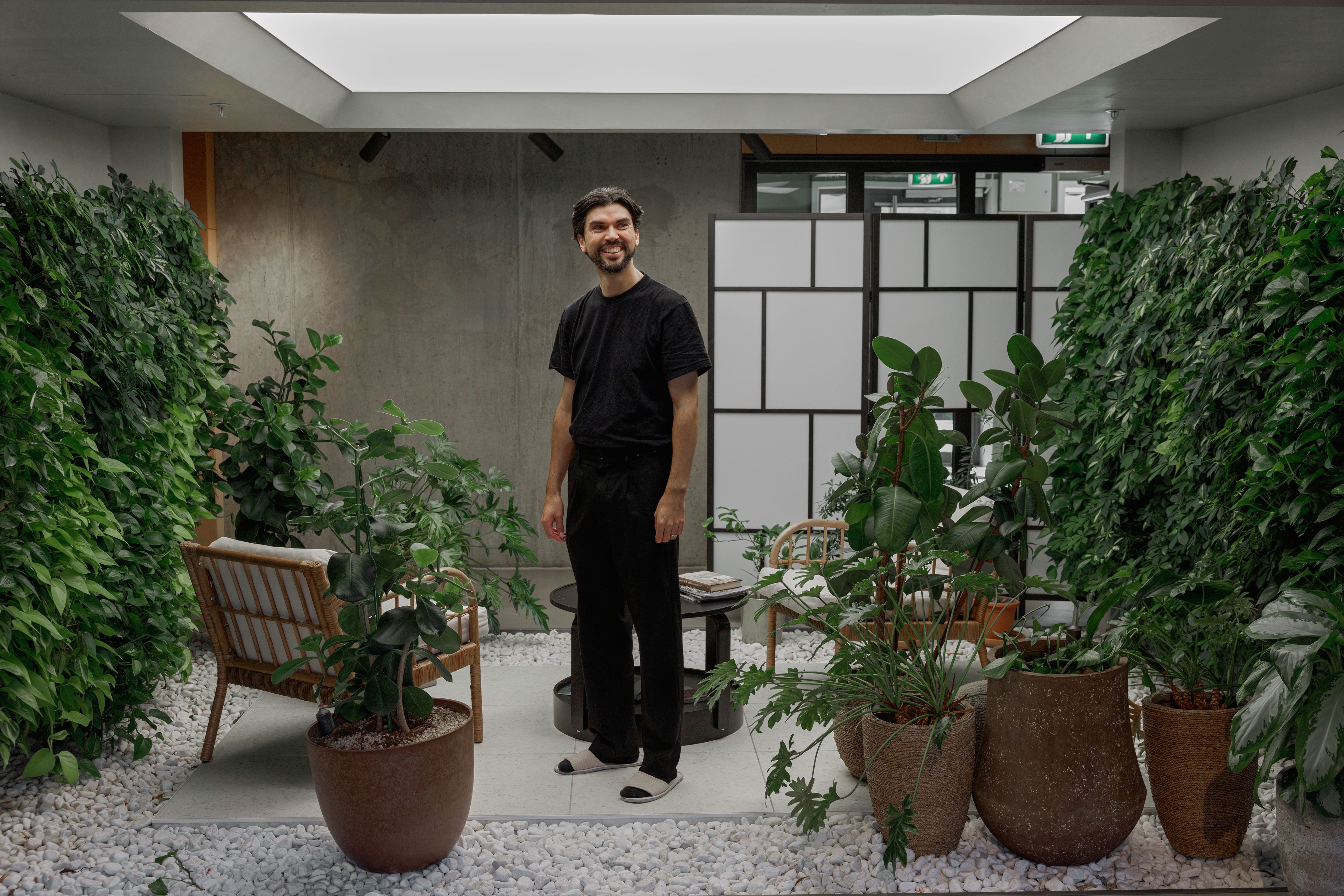 Prosjektleder for Living Lab, Daniel Silva står i et rom fullt av grønne planter.