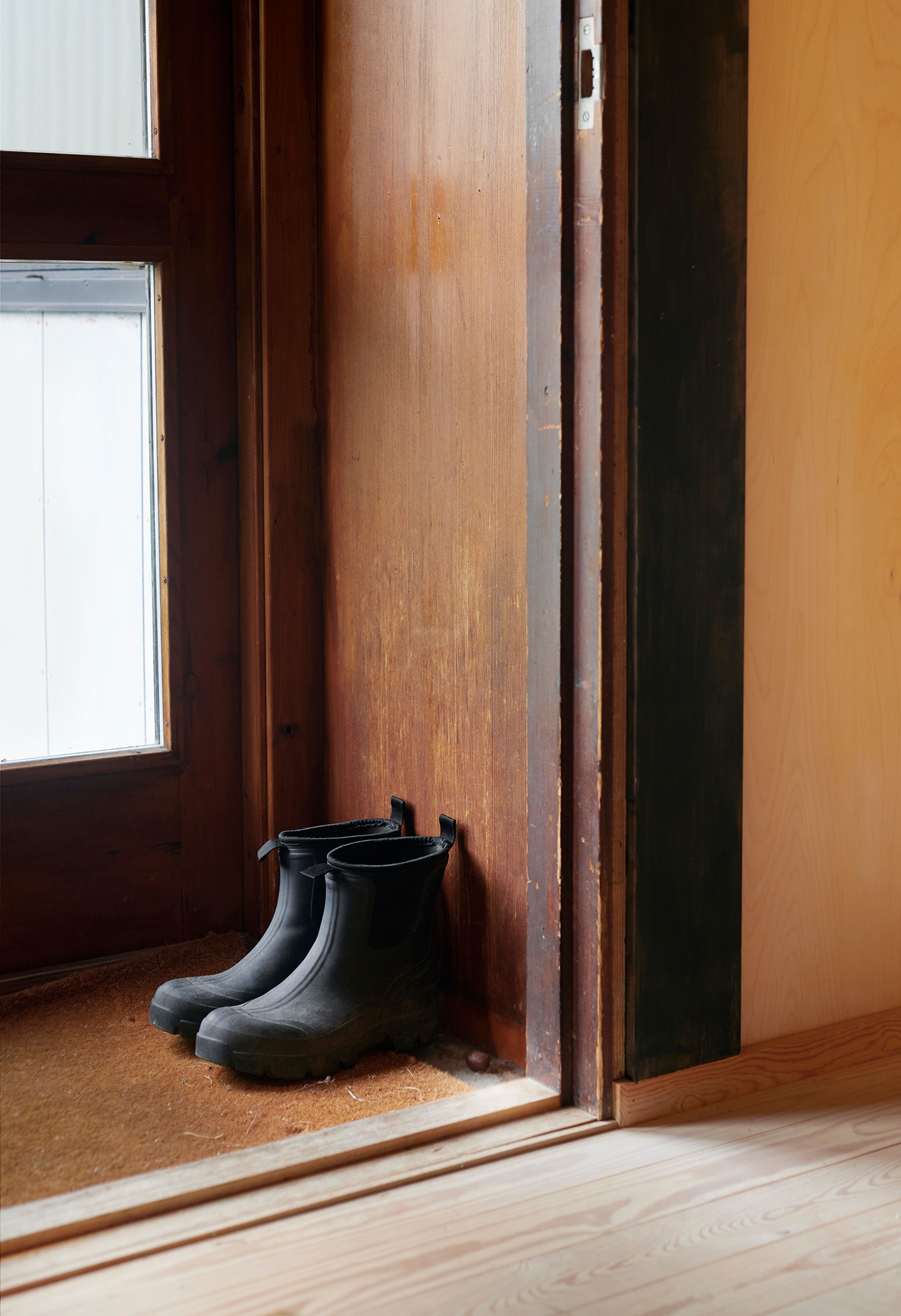 Et lite vindfang med noen sko på gulvet.