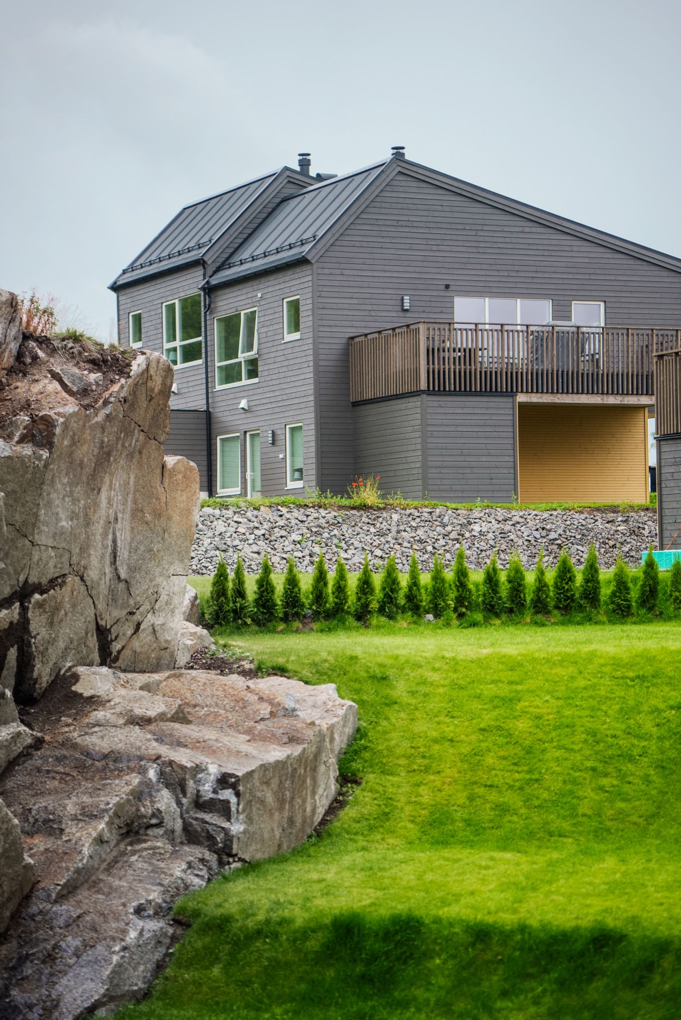 Berg og grøntareal i forgrunnen, hus på Solkollen i bakgrunnen.