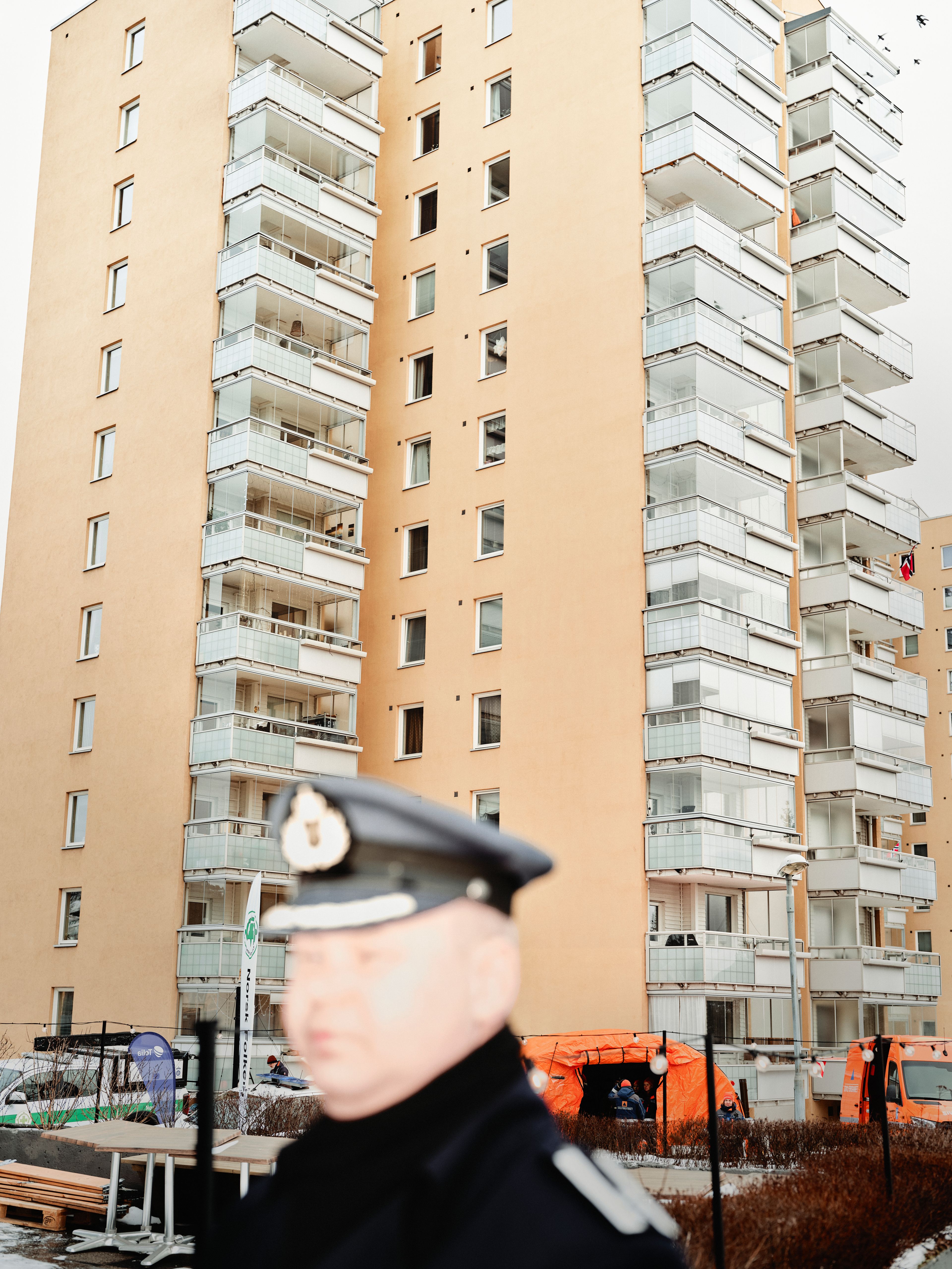 Et ufokusert bilde av politimann foran Bjerke borettslag.