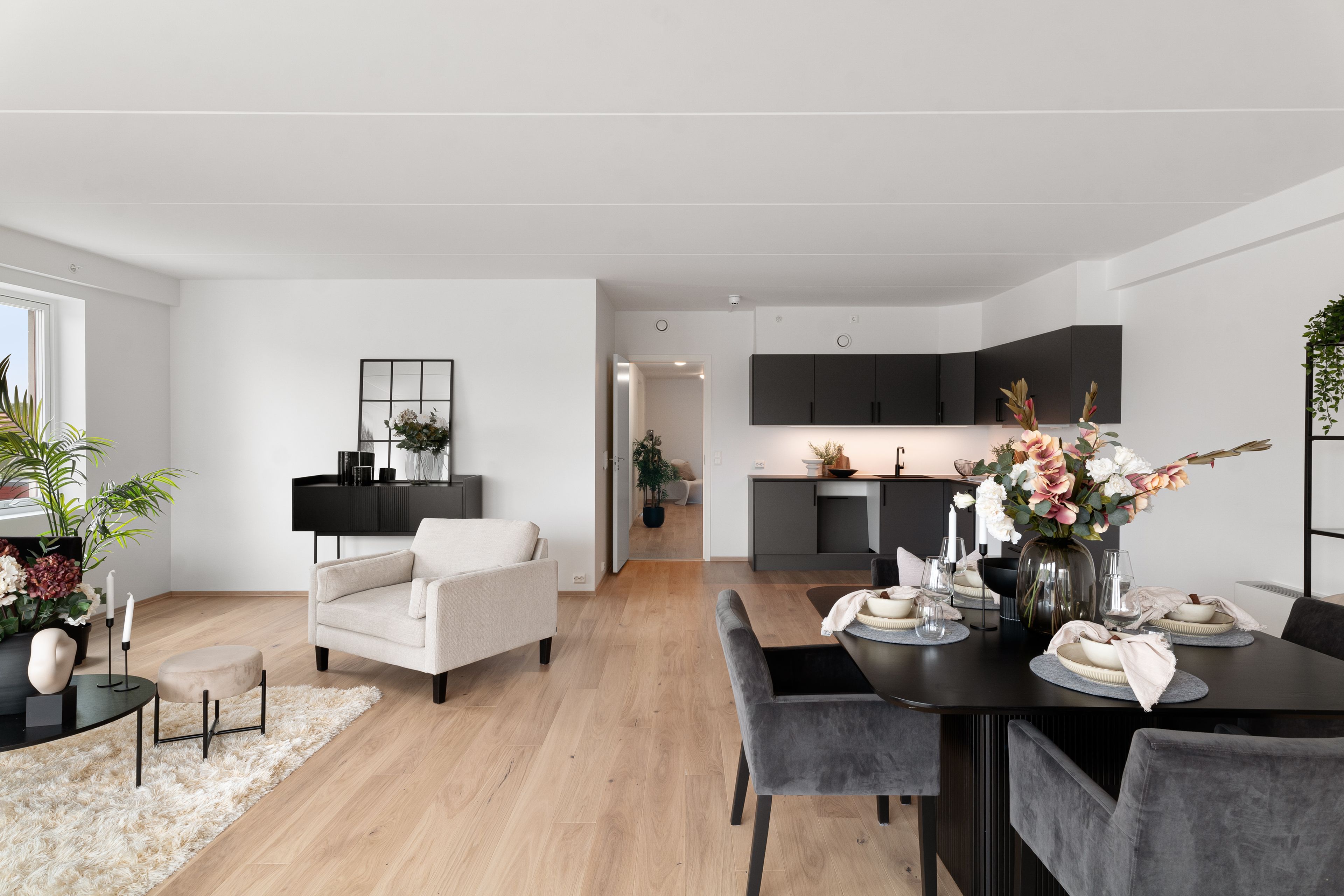 Foto av stue og kjøkken i en leilighet i Mariebo, med plass til sofa og spisegruppe.