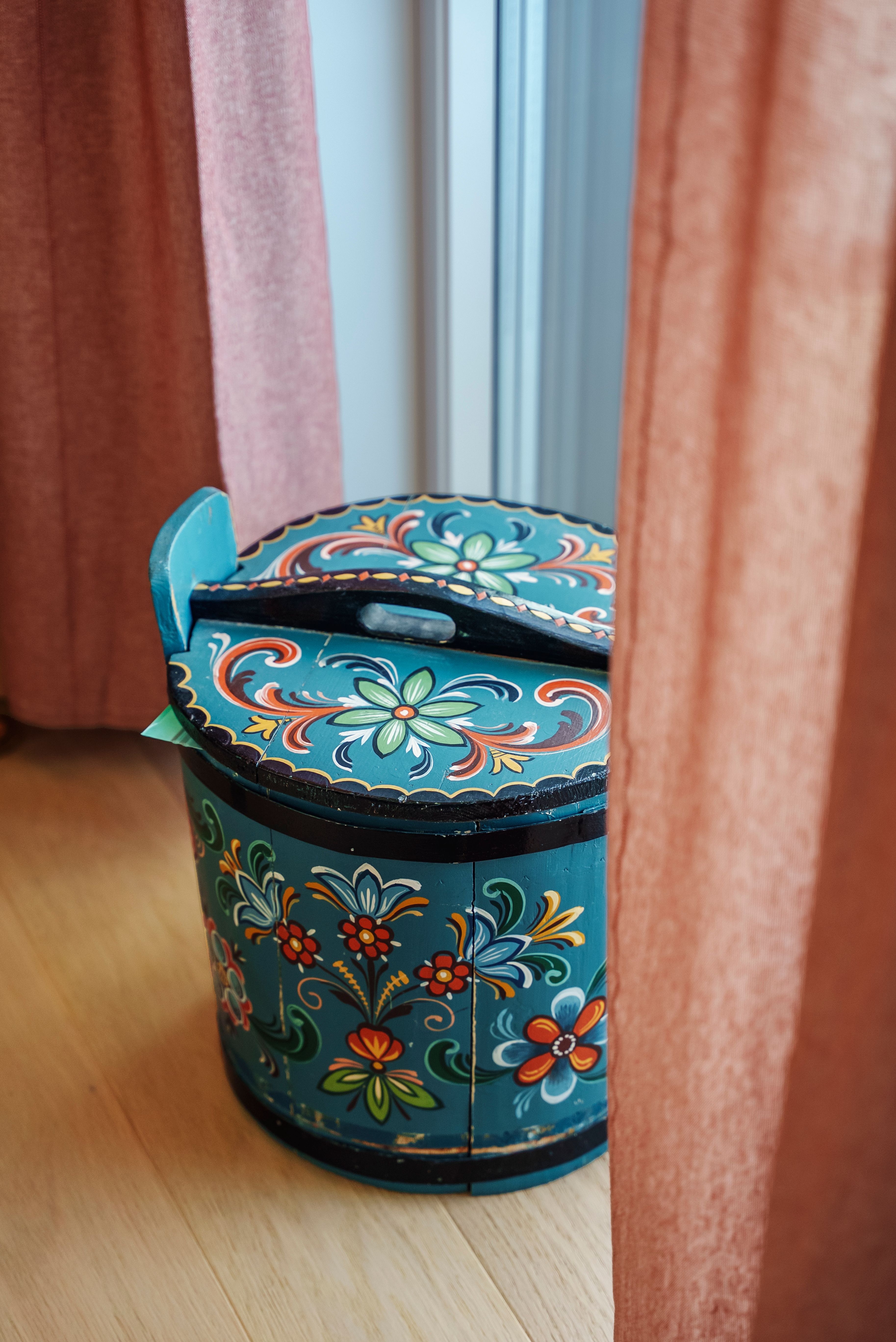 Nærbilde av en gammel, rosemalt tine