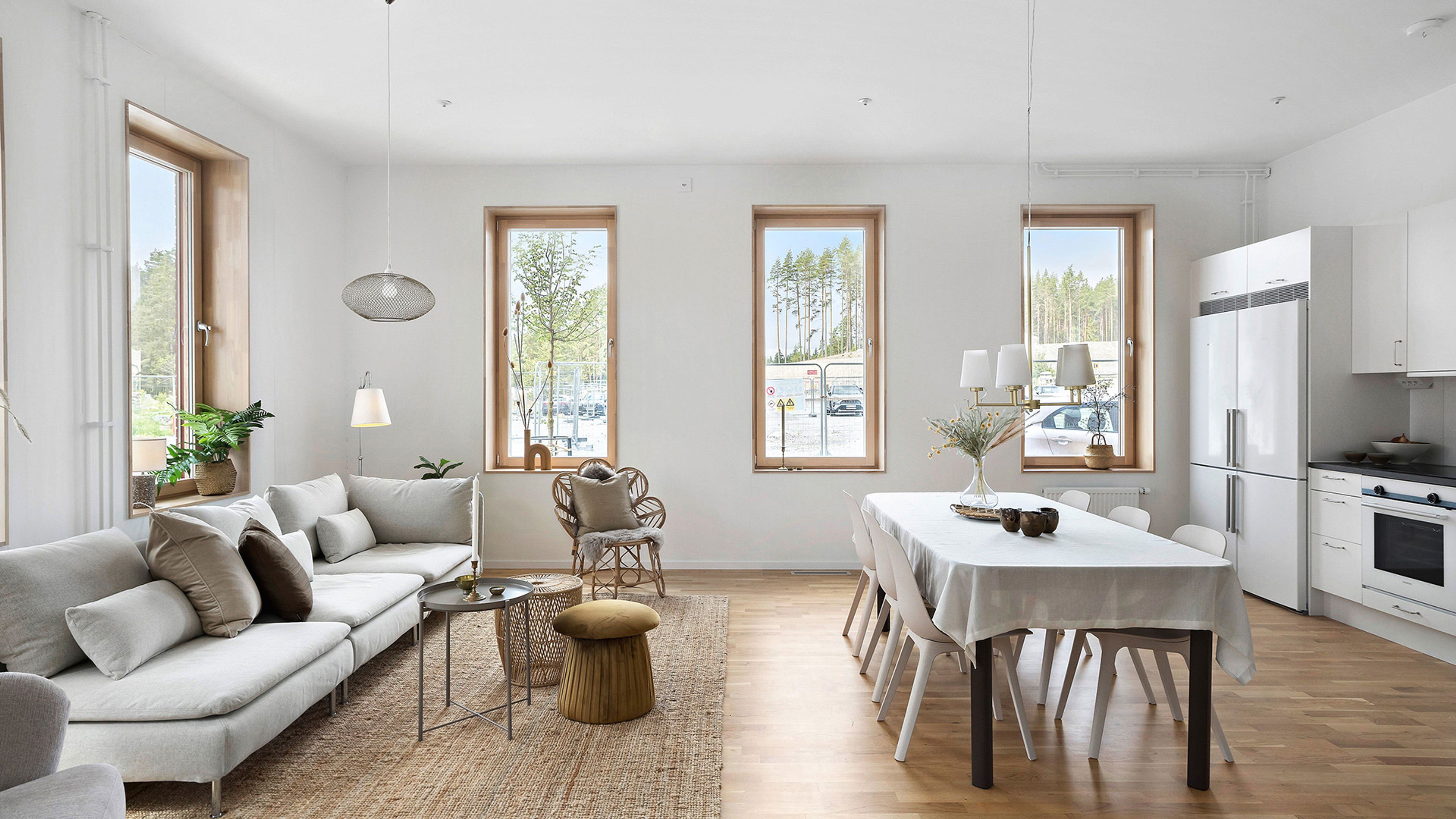 Foto av ett stort vardagsrum med soffa till vänster och matplats med köksbänk till höger