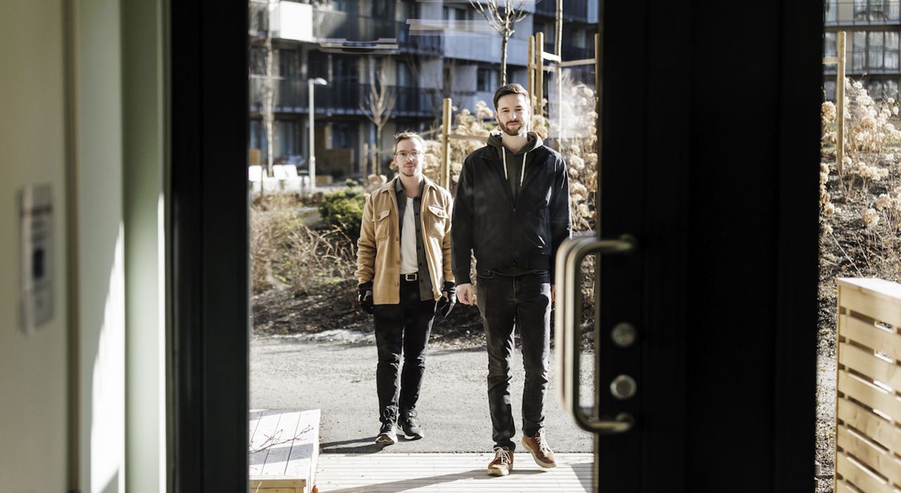 Fotografi av Mikkel og Sebastian som åpner døra med OBOS-Nøkkel