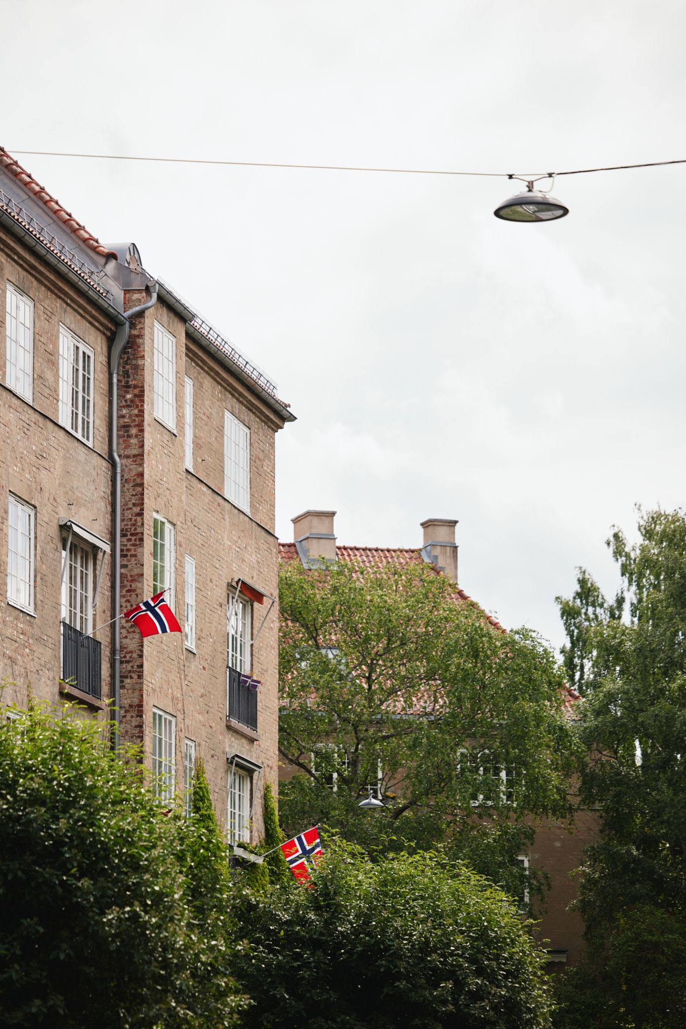 Foto av flaggene som henger på fasaden til boligsameiet.