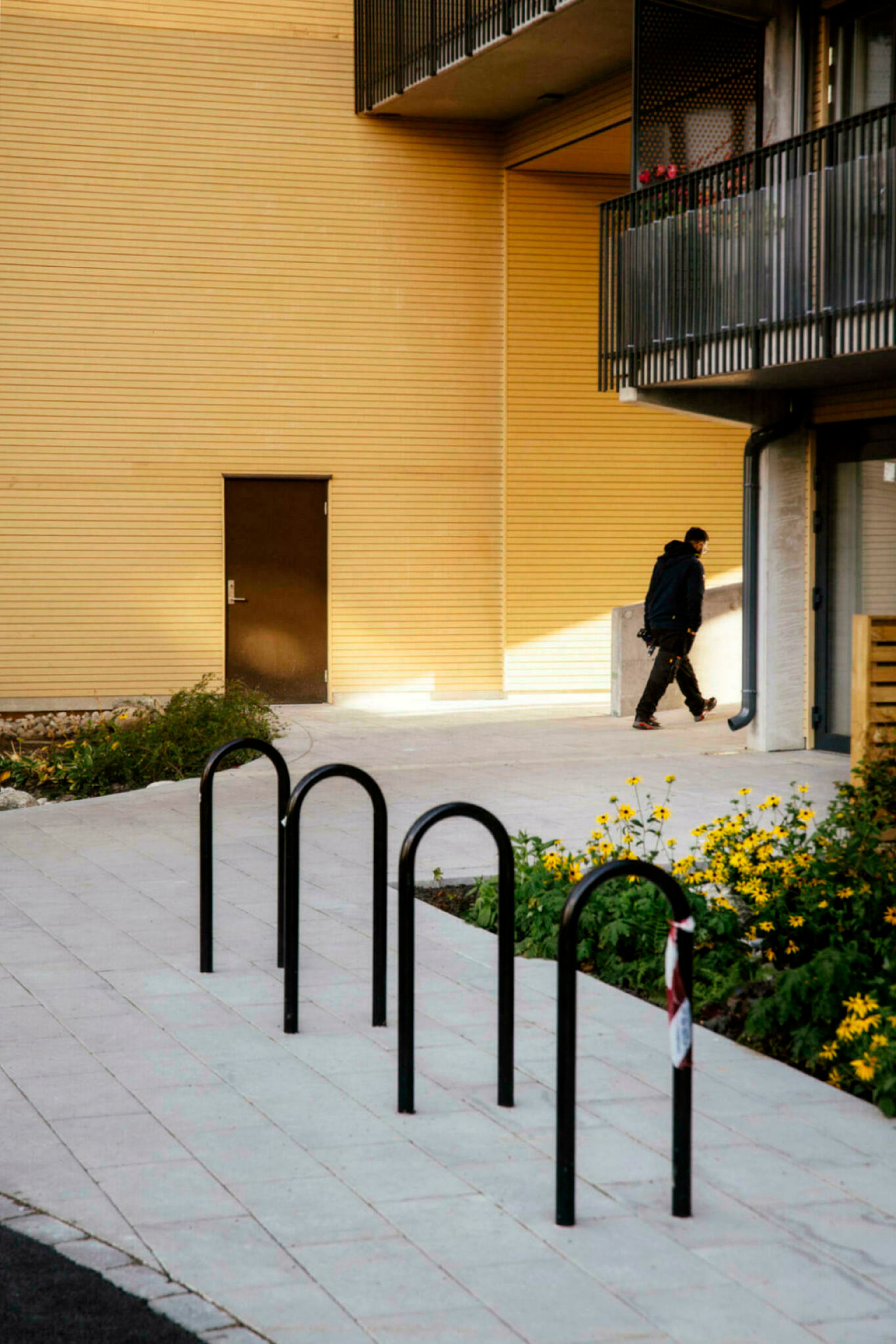 En mann går langs en av de gule fasadene i Ulvenparken borettslag på Ulven i Oslo.