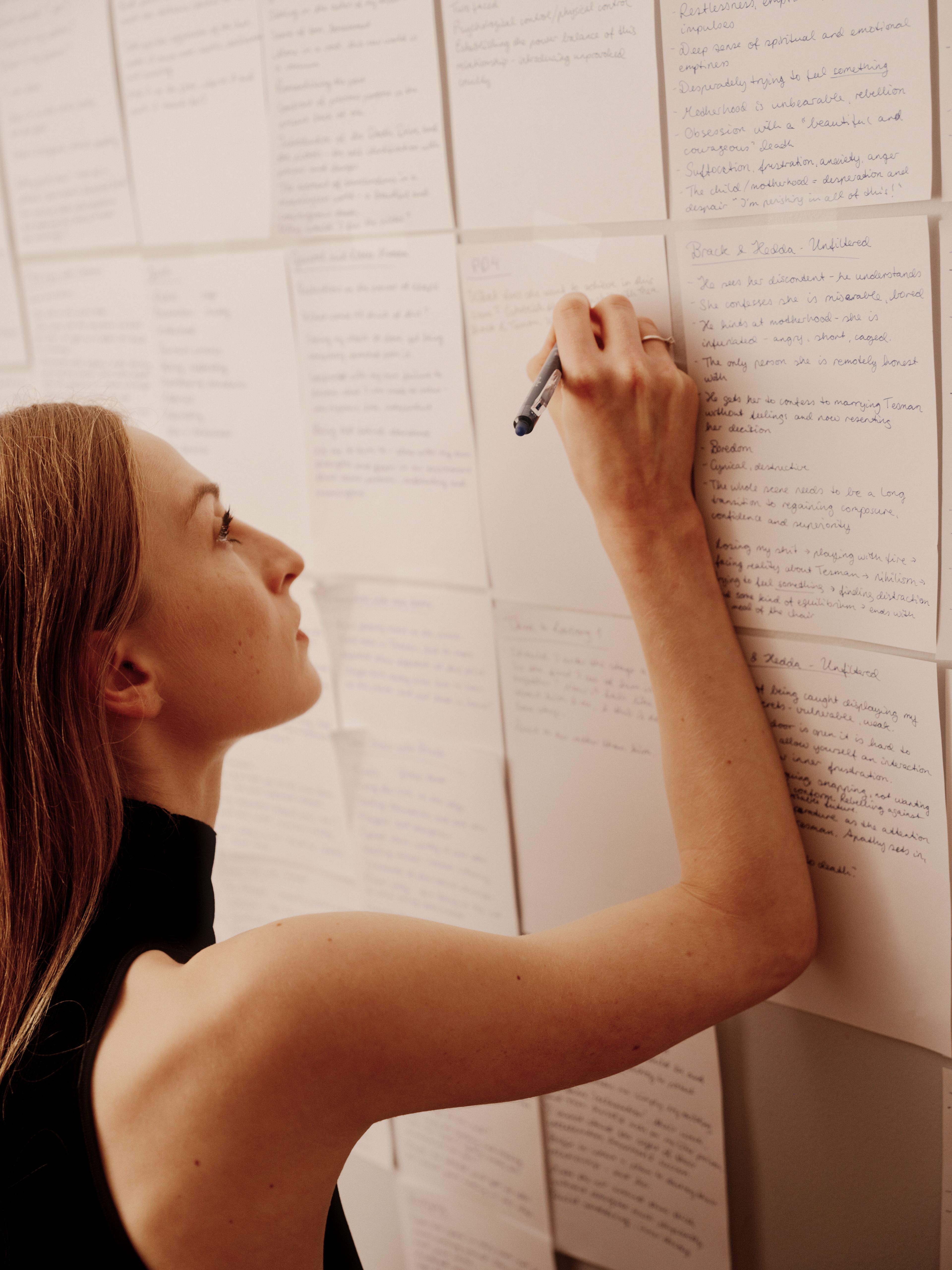 Grete Borud Nybakken noterer på manuset på veggen.