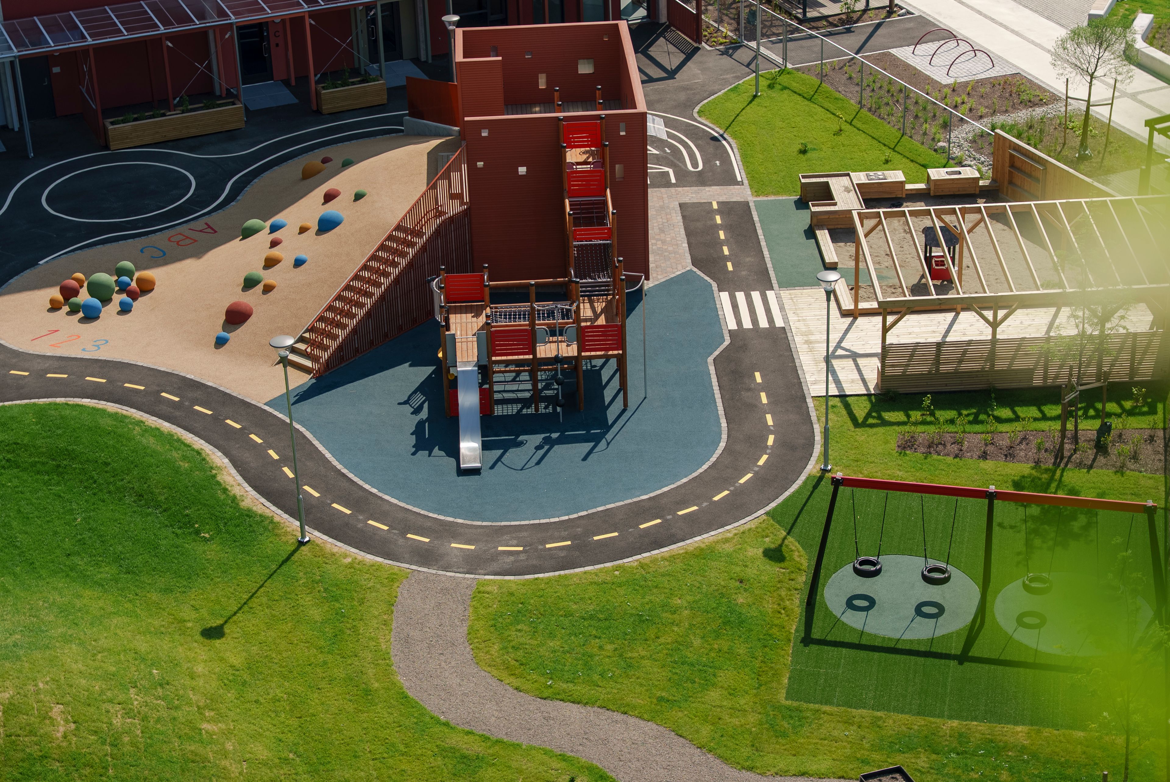 Et oversiktsbilde av fellesområde med stor lekeplass og sitteplasser.