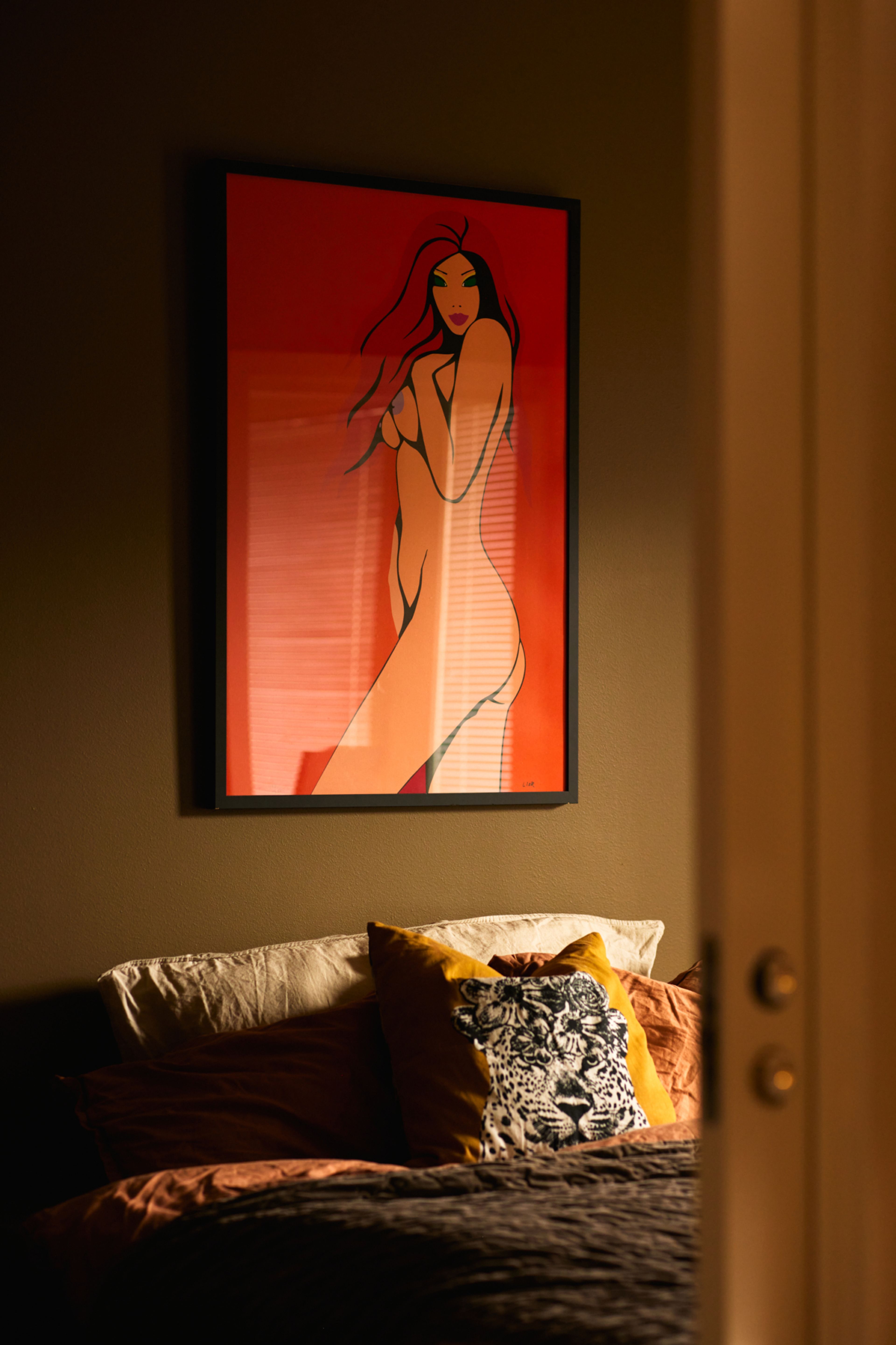 Bilde av soverommet. Her er det også en innrammet illustrasjon på veggen.