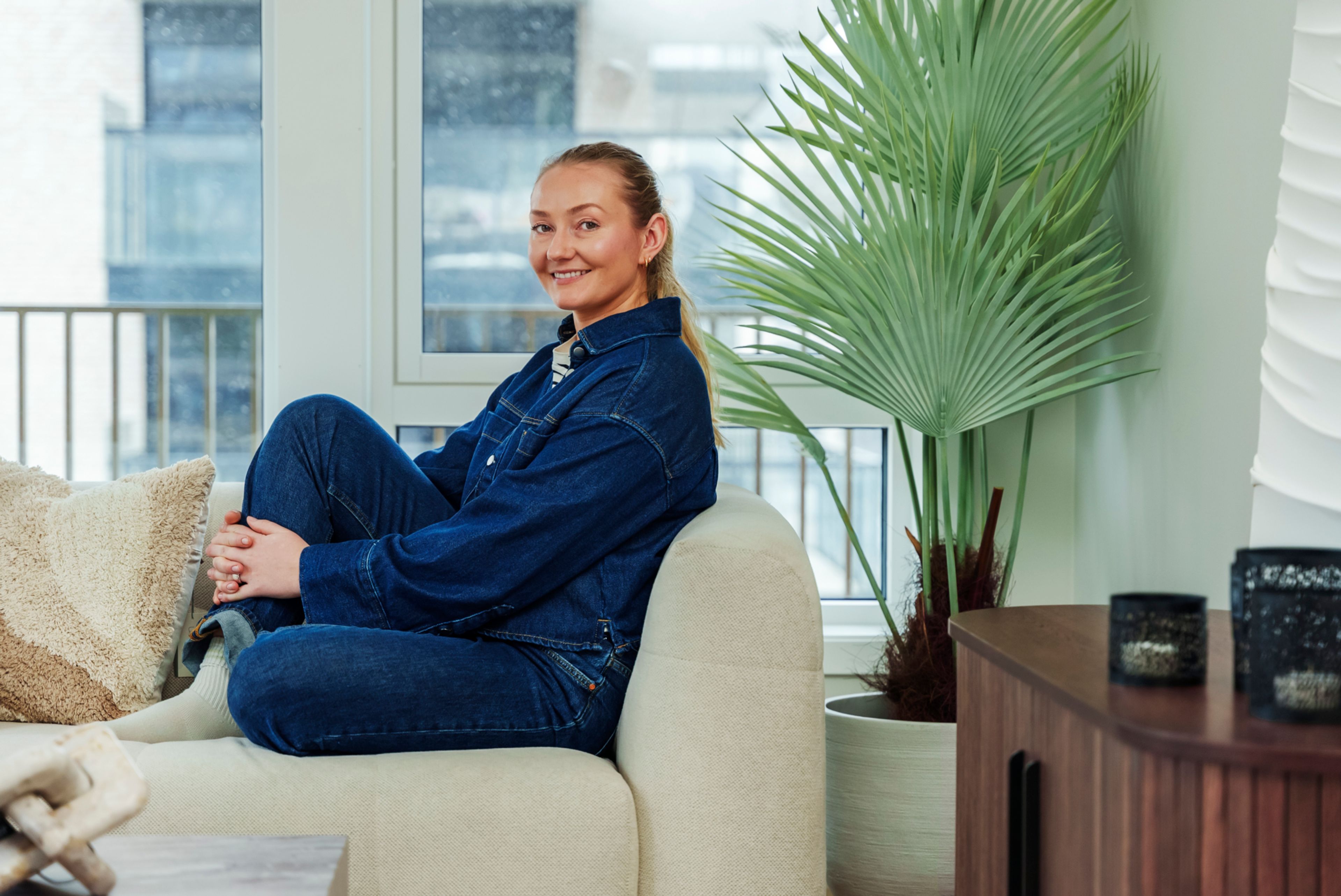 Bohus-stylist Guro Gundersen sitter i en beige sofa