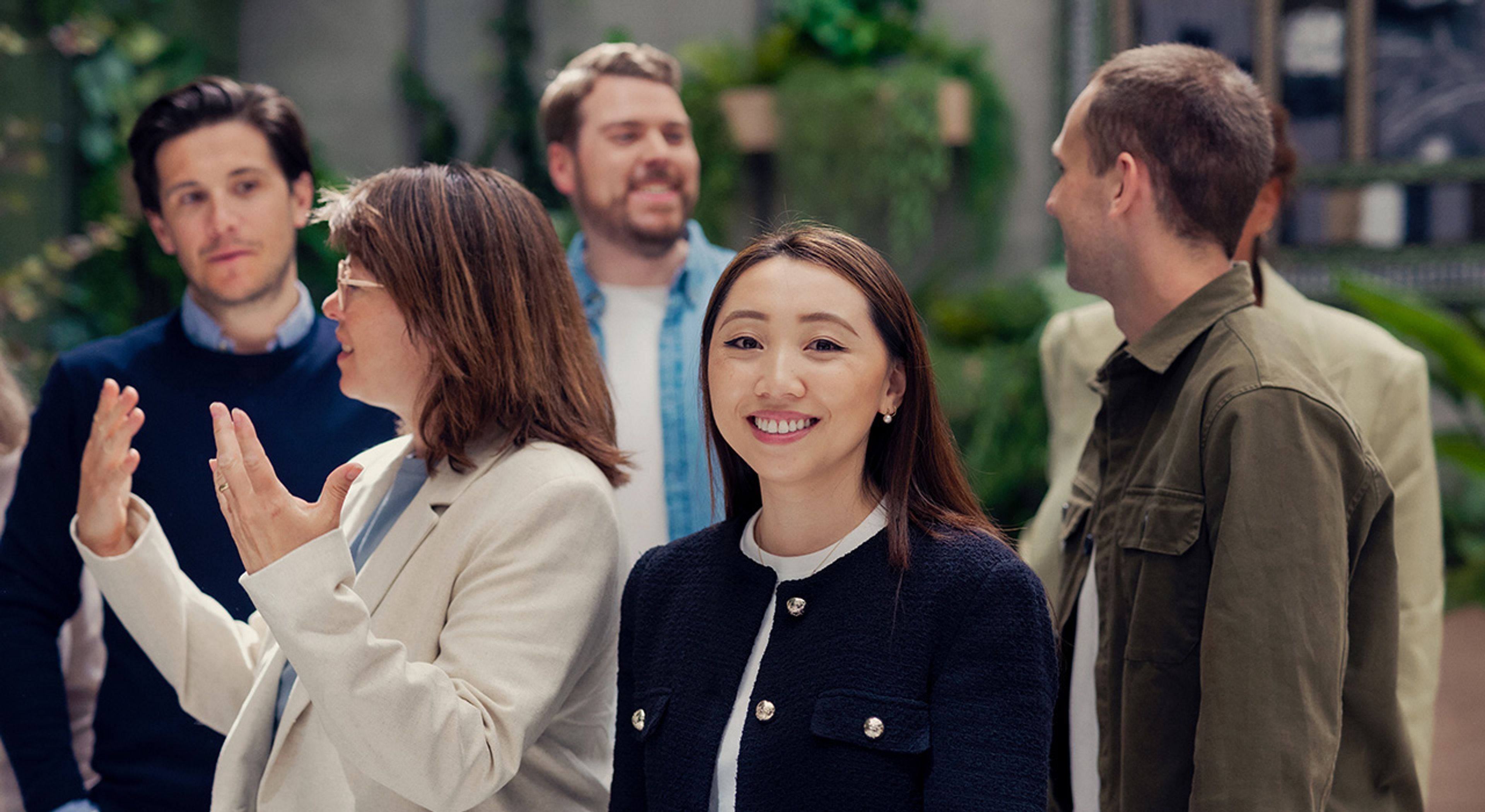 a group of people are standing next to each other and talking .