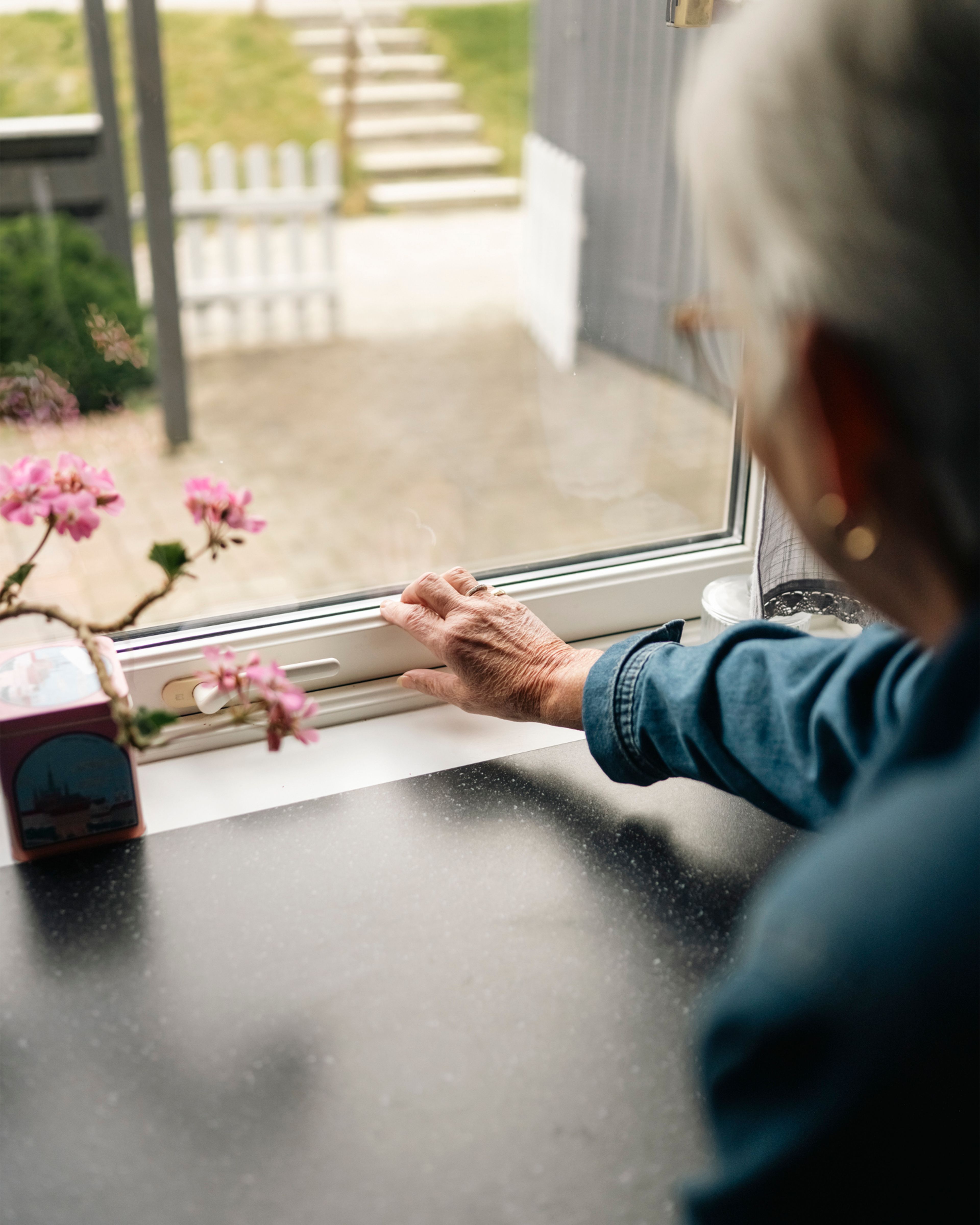 Anne-Berit Snekkersveen sitter ved kjøkkenvinduet og kjenner etter trekk langs vinduskarmen.