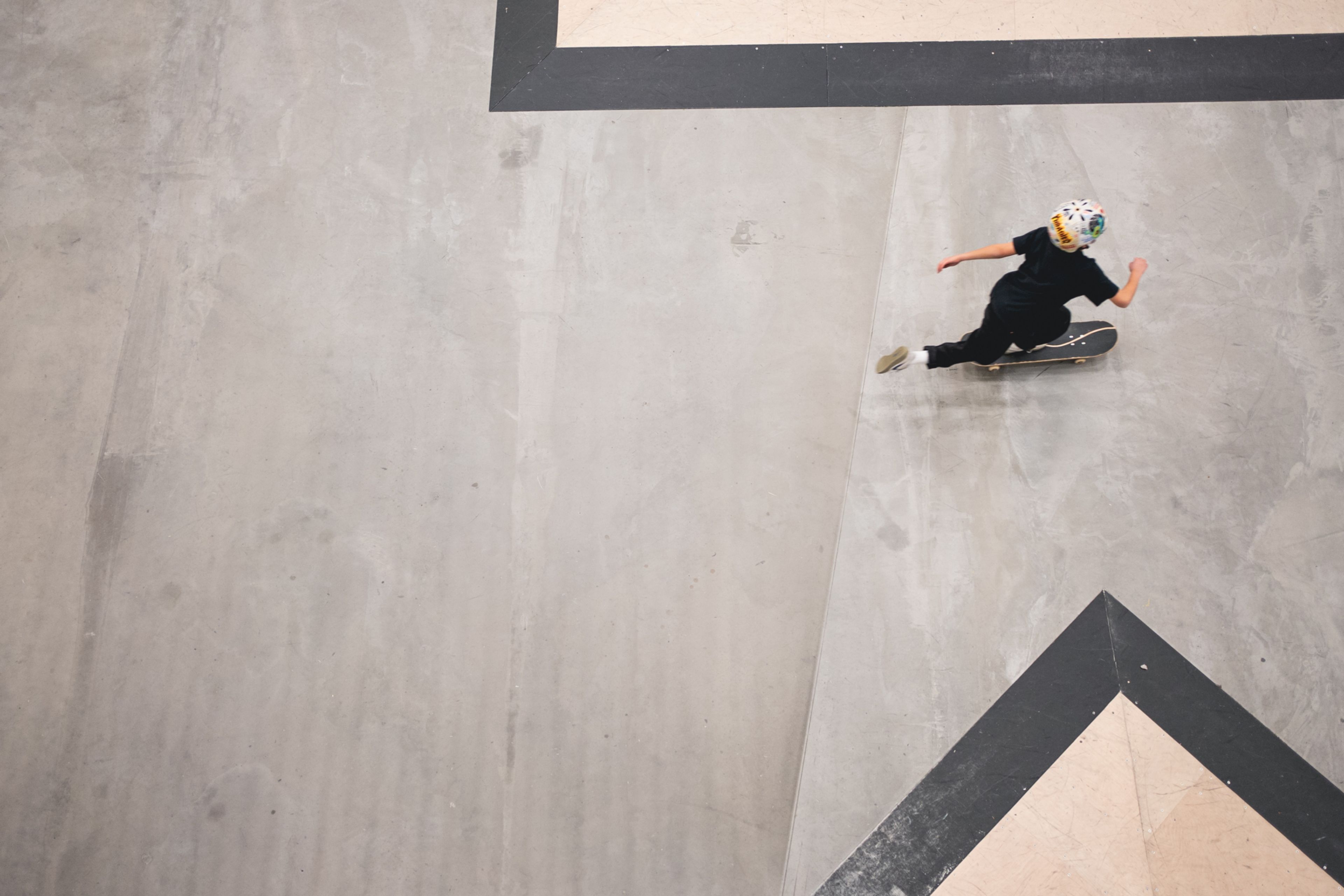 Foto fra fugleperspektiv av en gutt som skater i Oslo Skatehall