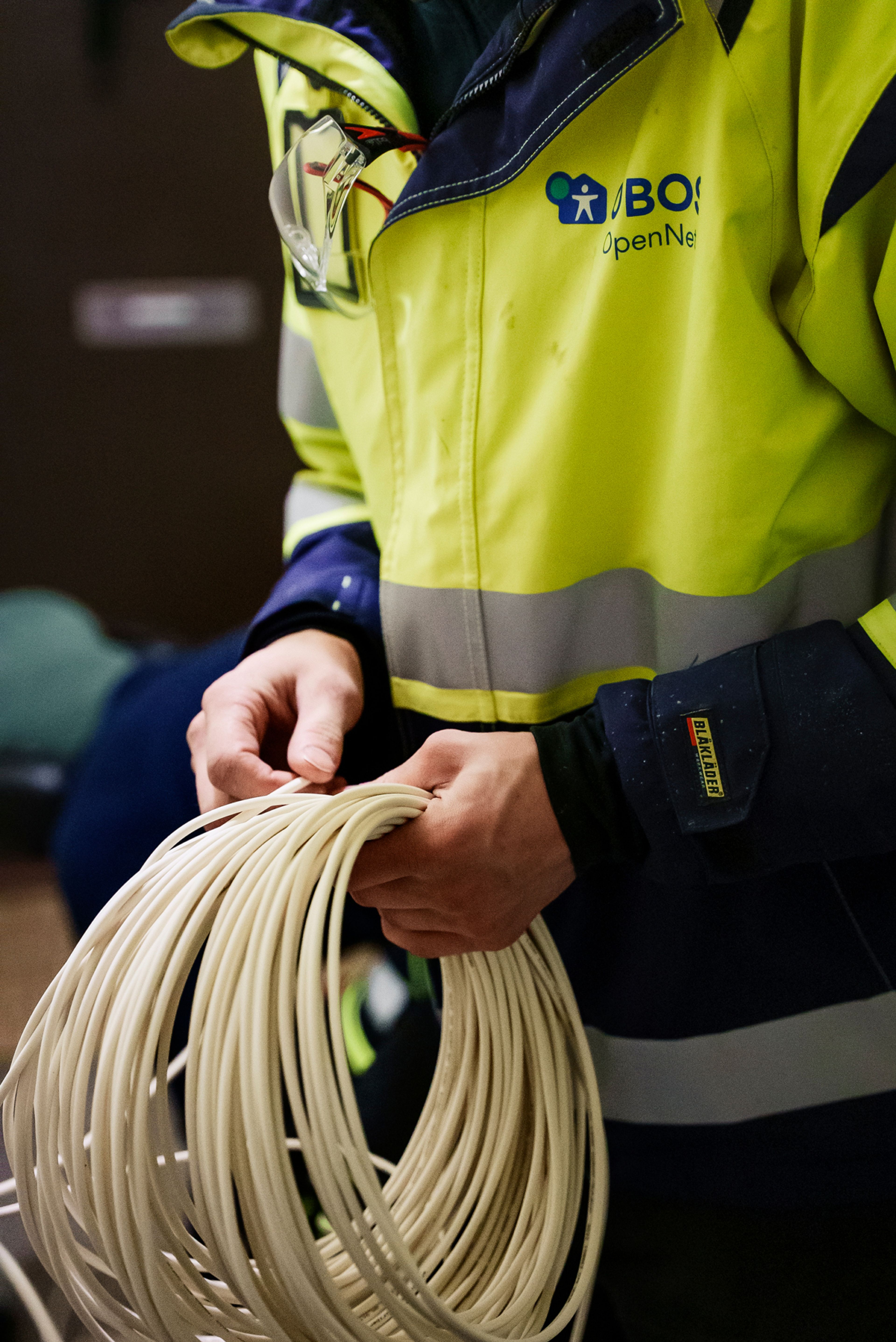 En tekniker holder en rull med fiberkabel.