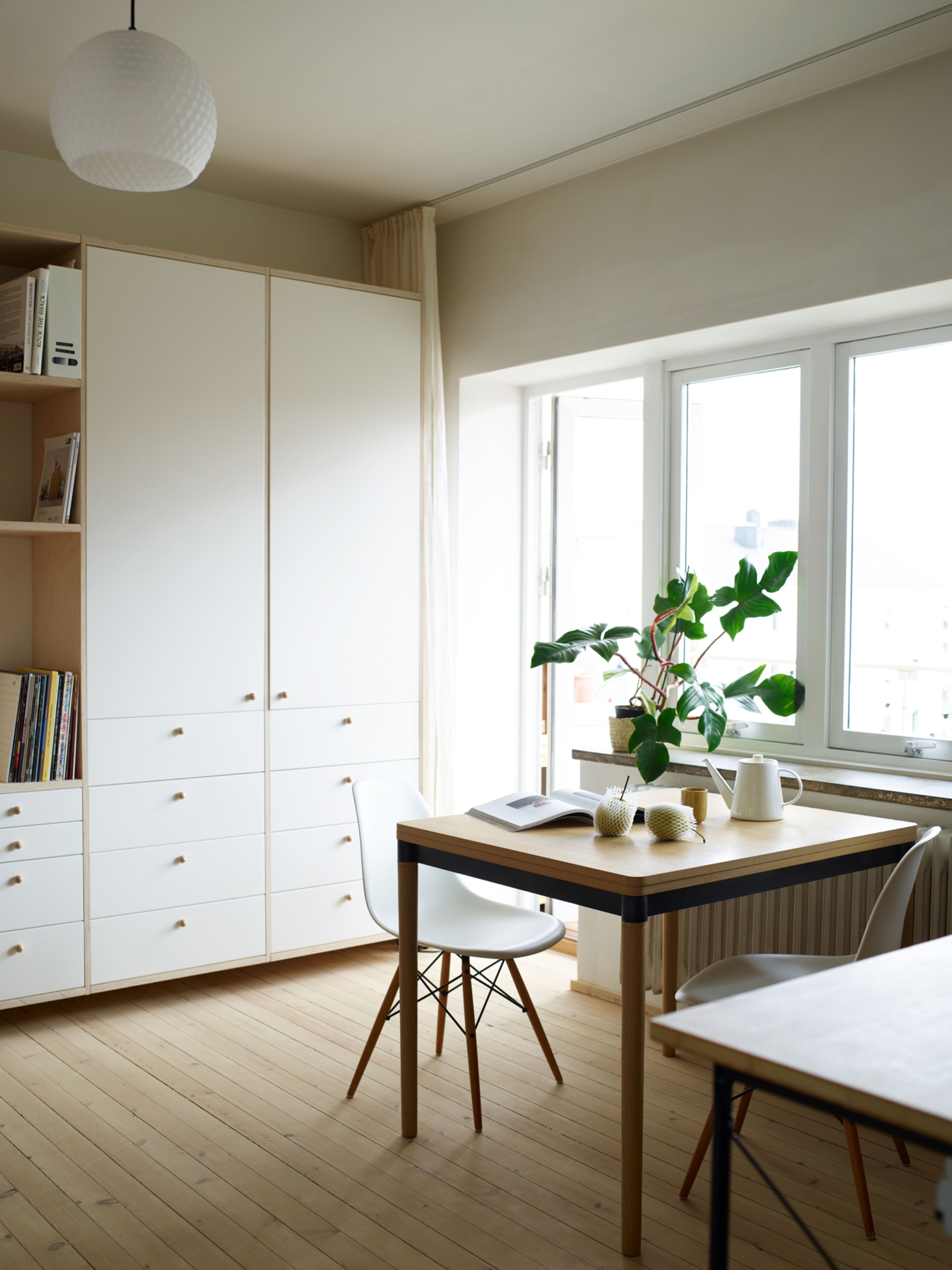 Bildet viser et hjørne av leiligheten med skap og spisebord.