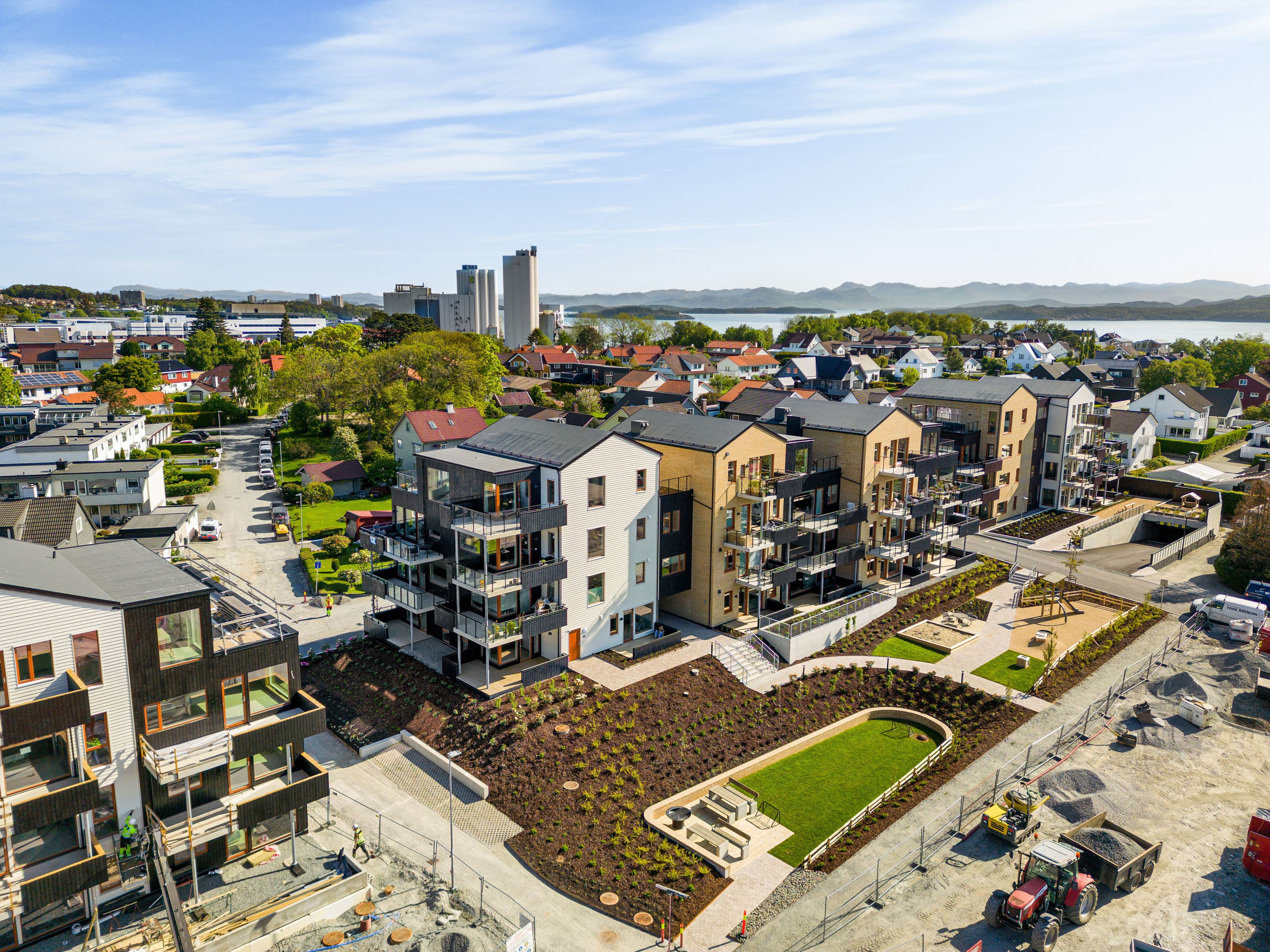 Foto av byggene i Mariebo med forskjellige fasader og grønt uteområde.