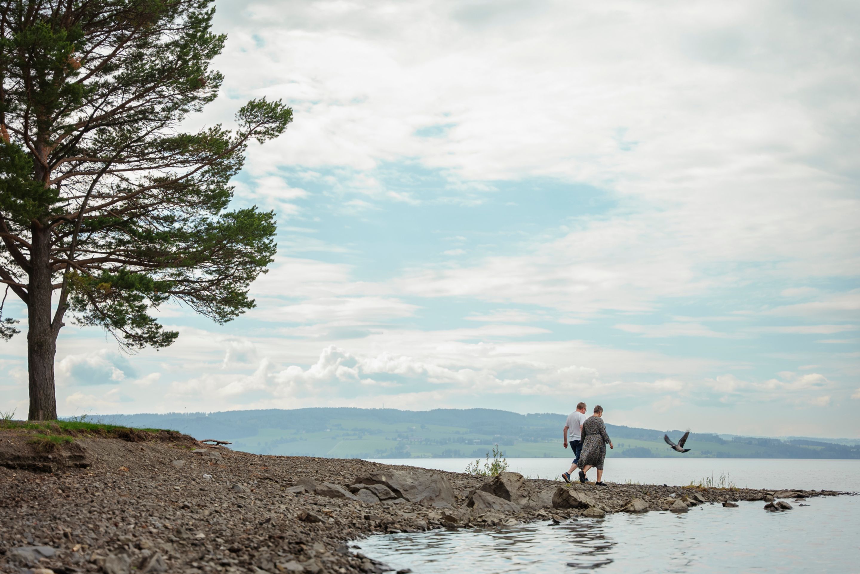 Bilde av Rune Gihlemoen og Ingrid Raasholm som går langs elvebredden ved Mjøsa