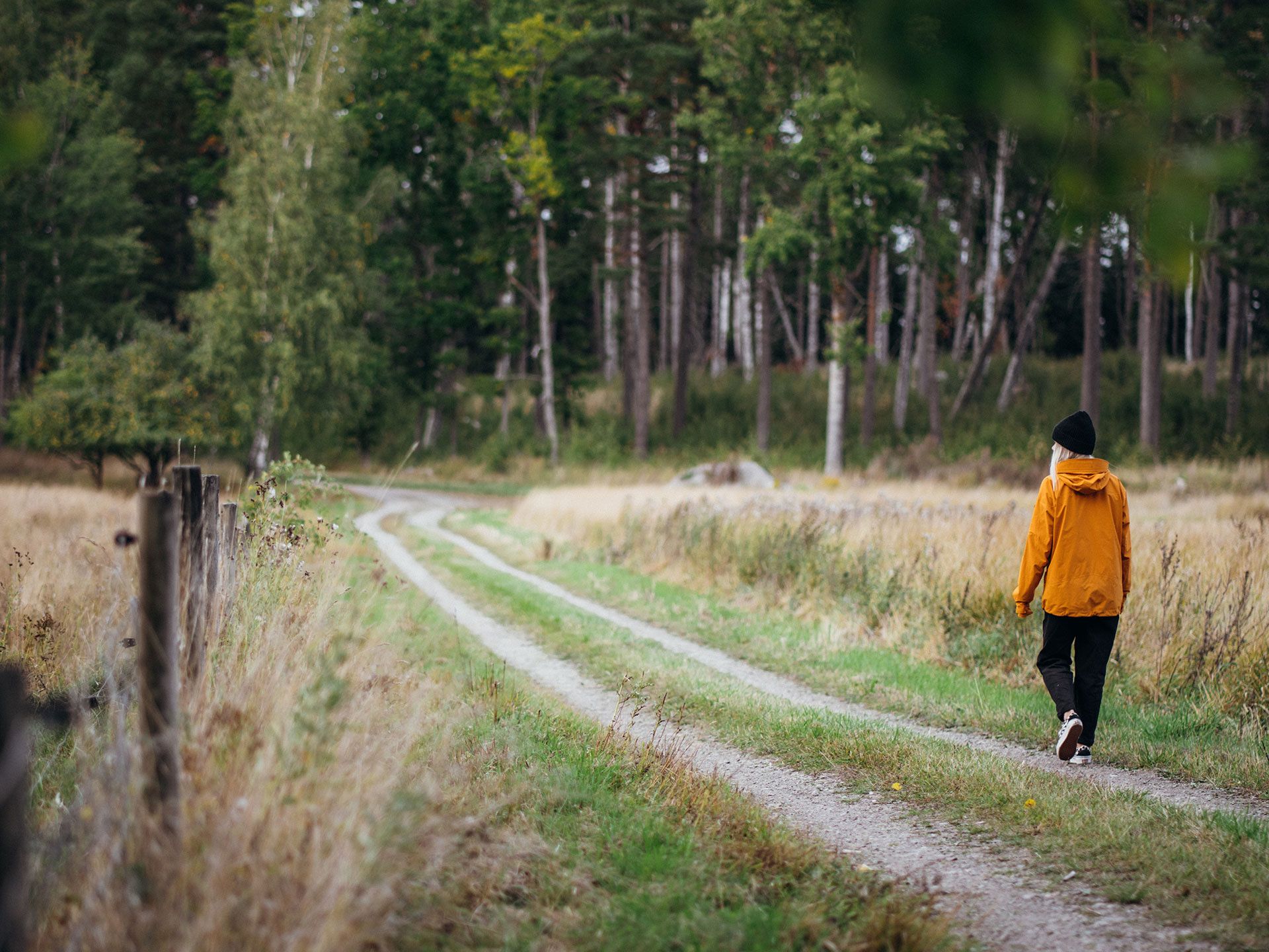 kvinna som promenerar vid en hage