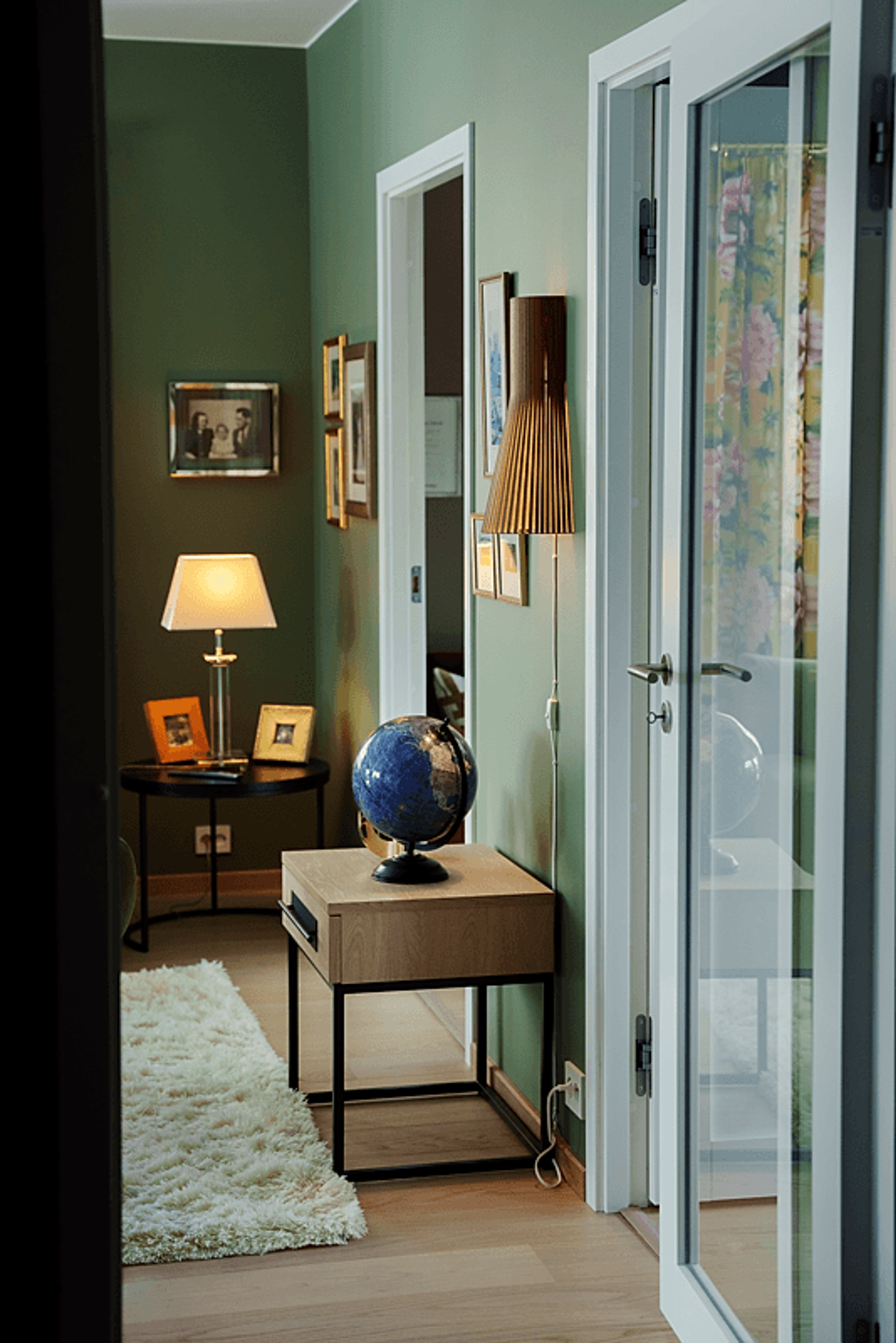 Bilde som viser den ene delen av stua, pyntet med en rekke bilder, møbler og gjenstander