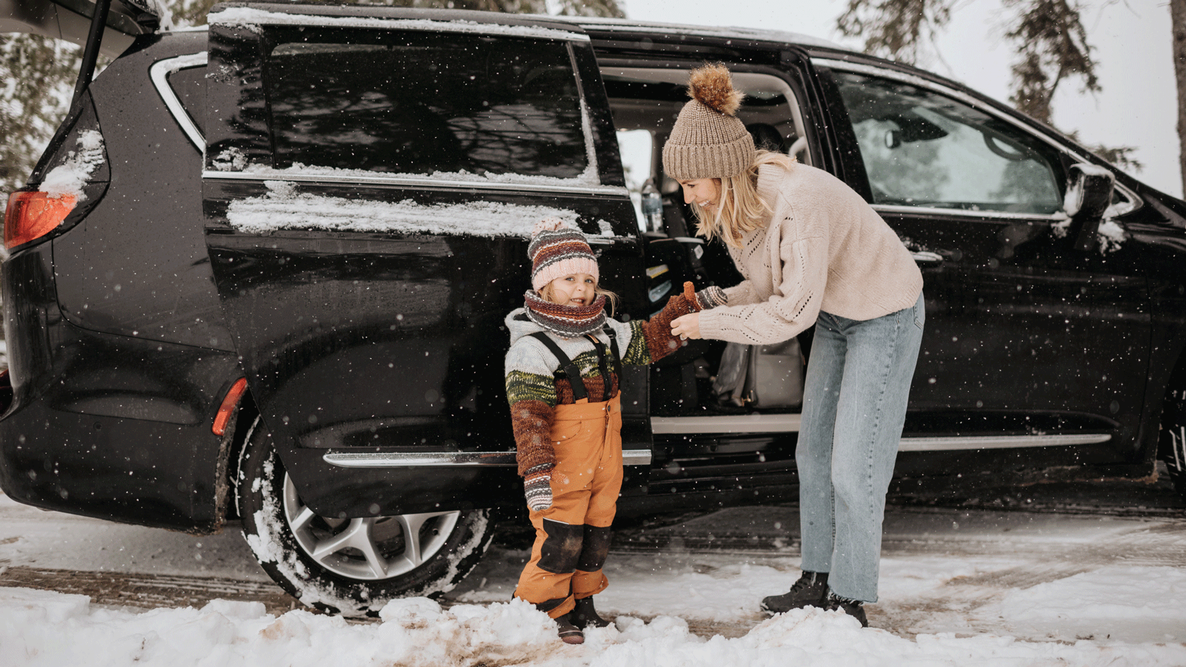mamma med barn utanför bil i snö