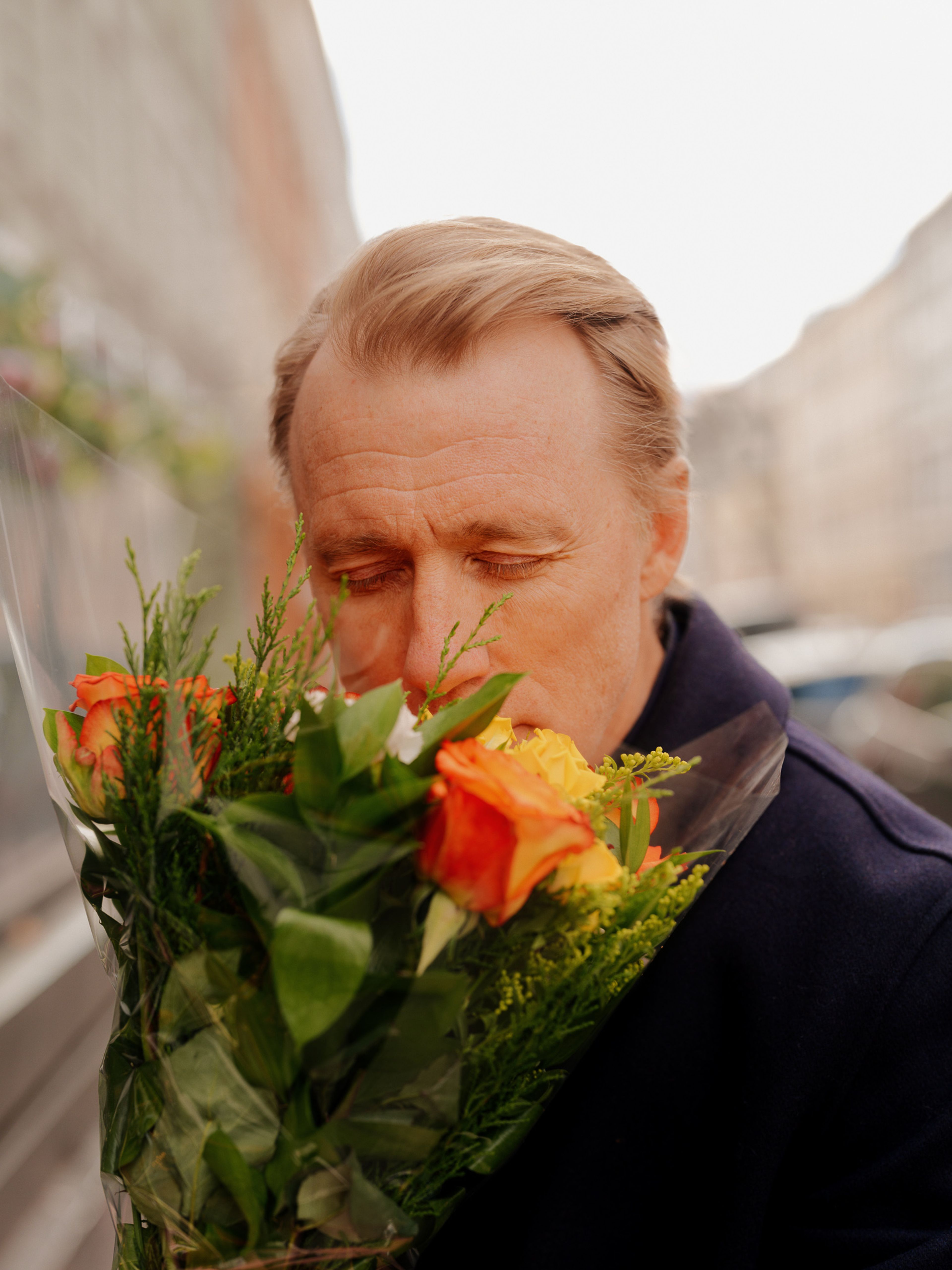 Thorbjørn Harr lukter på blomsterbuketten han holder i hånda.