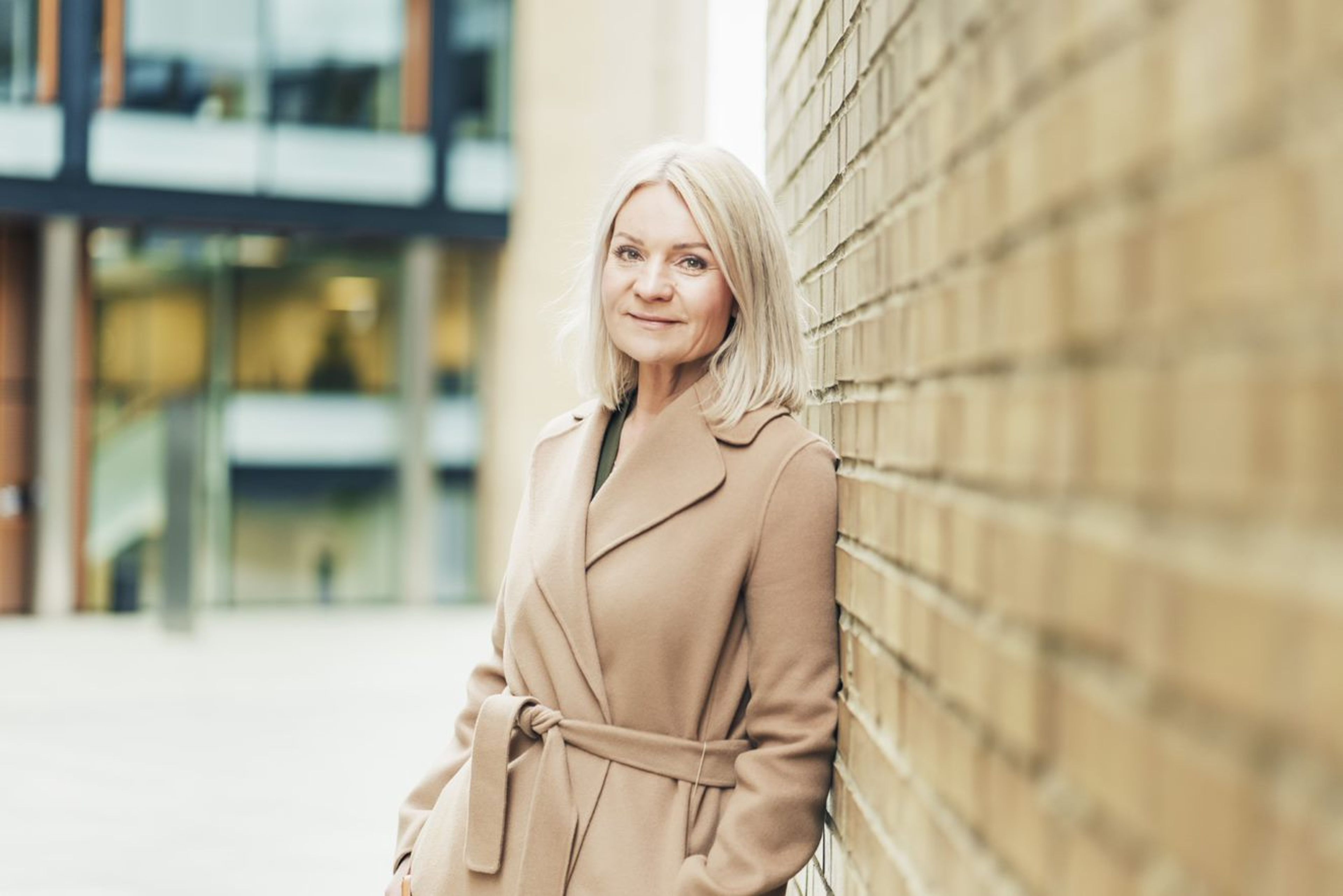 Trude Olaussen, leder for økonomisk kriminalitet i OBOS-banken, lener seg mot en murvegg