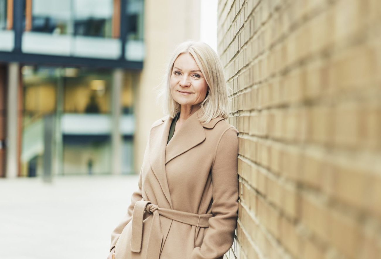 Trude Olaussen, leder for økonomisk kriminalitet i OBOS-banken, lener seg mot en murvegg