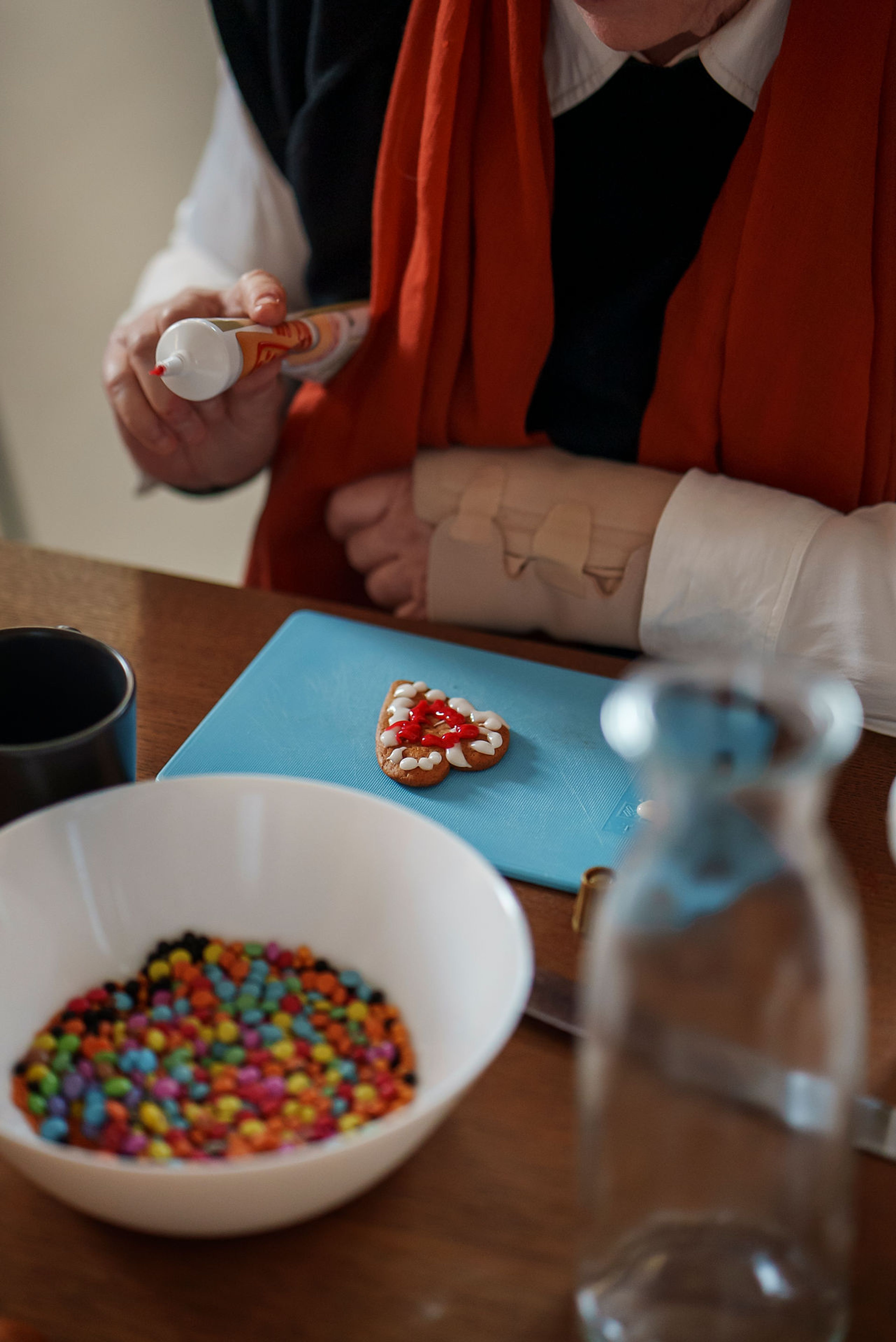 Bilde av en aldrende hånd som holder en tube glassur over en pepperkake.