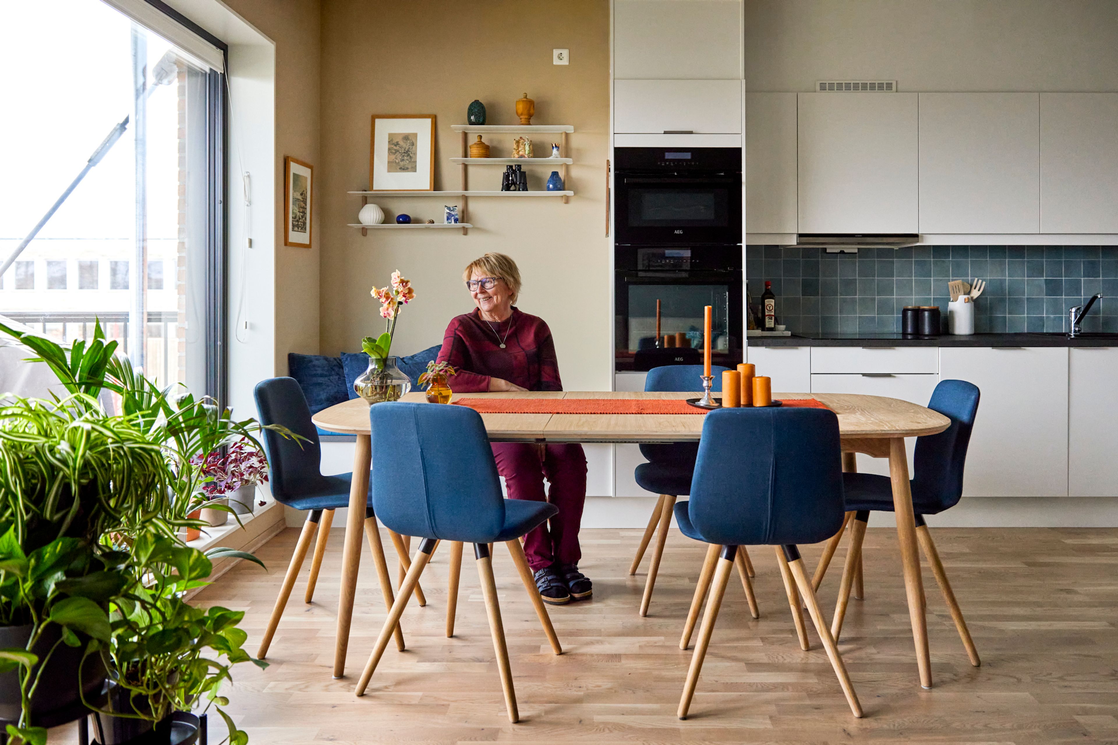Bilde av Marit Helene Holen sittende på en stol i leiligheten hennes på Ulven T.