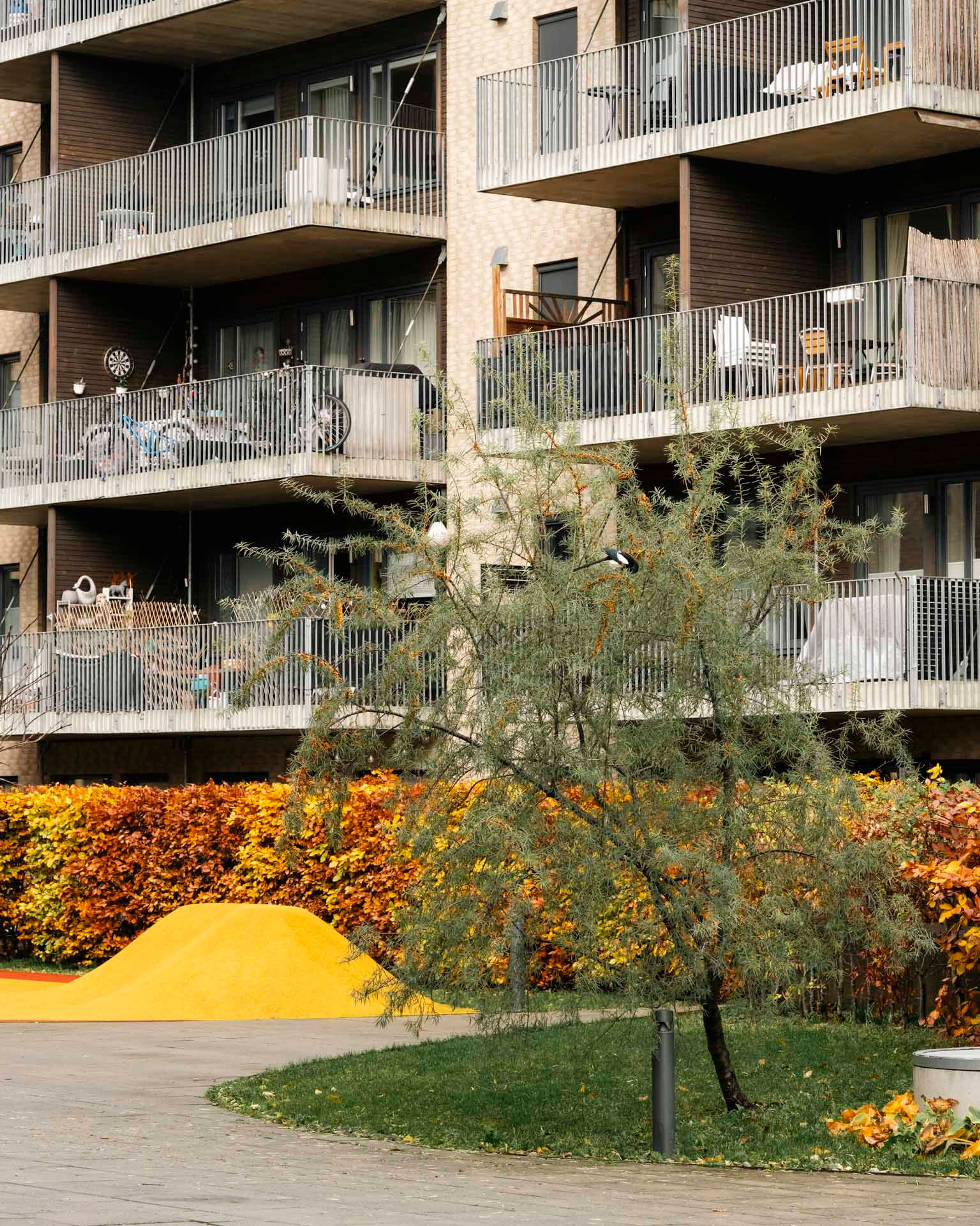 Leilighetsbygg med balkonger og grønt uteområde i sameiet Tiedemandsbyen Petersborgkvartalet