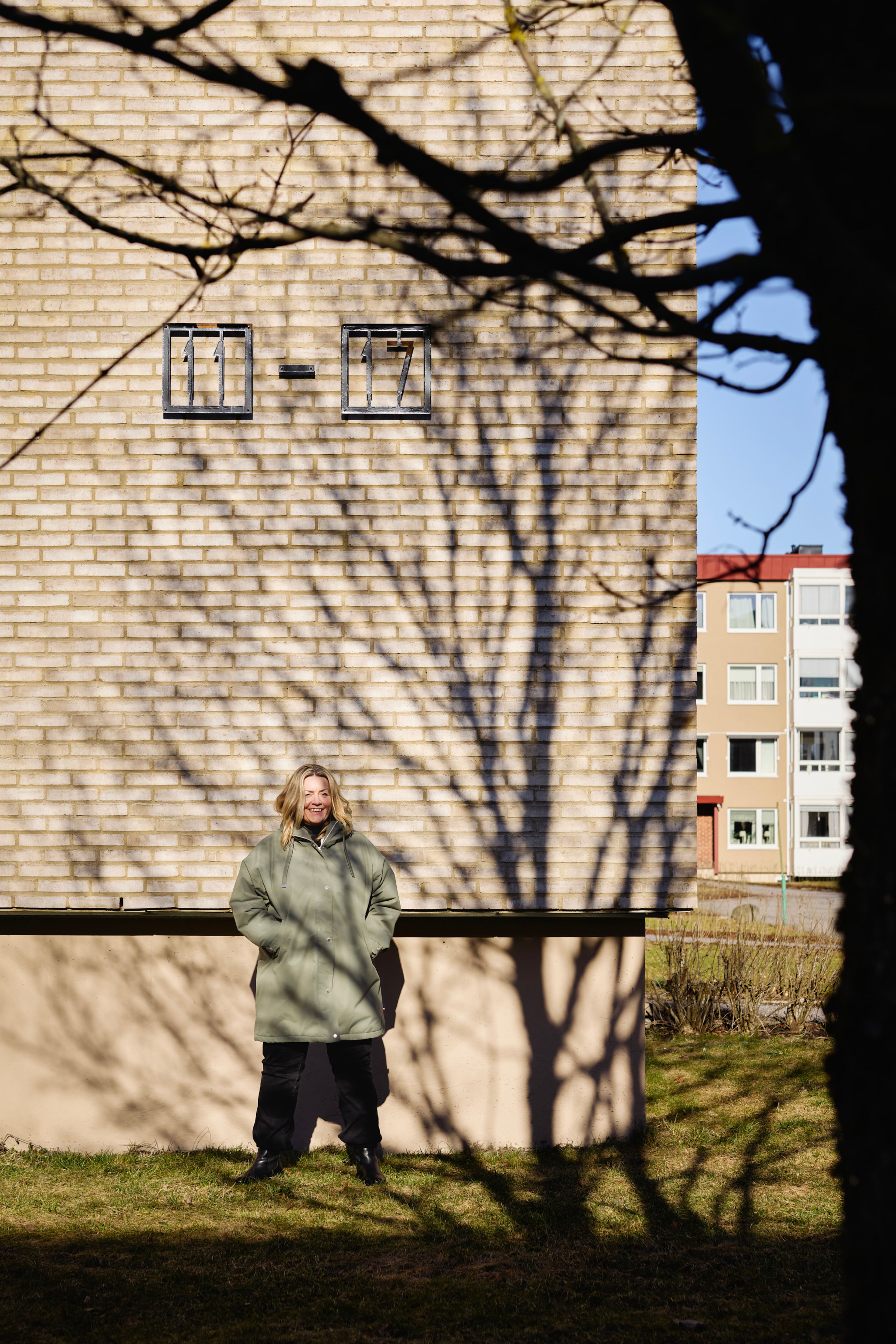 Styreleder i Rognerud borettslag, Tone Gulliksen, står ute ved en av blokkene i borettslaget.