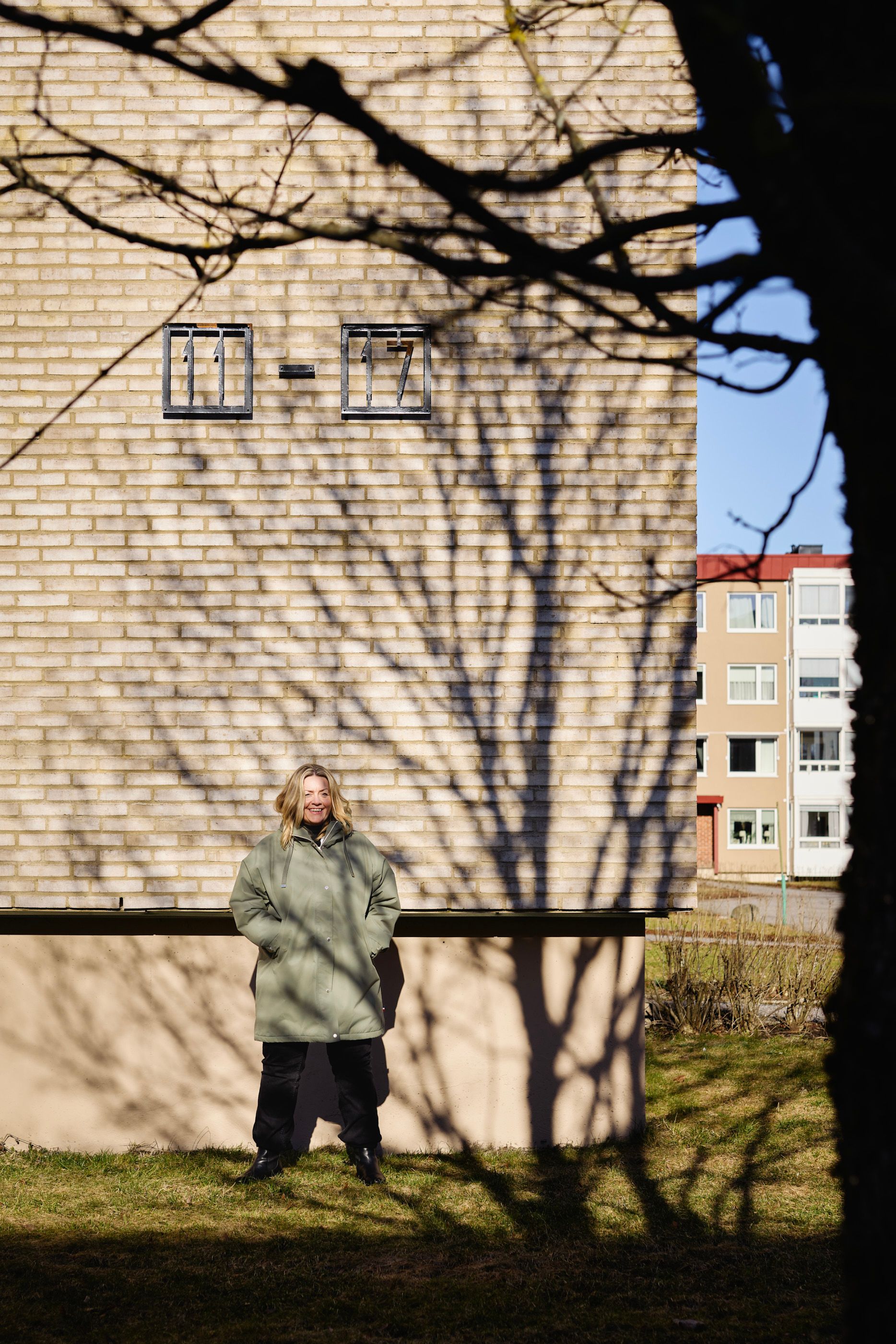 Styreleder i Rognerud borettslag, Tone Gulliksen, står ute ved en av blokkene i borettslaget.