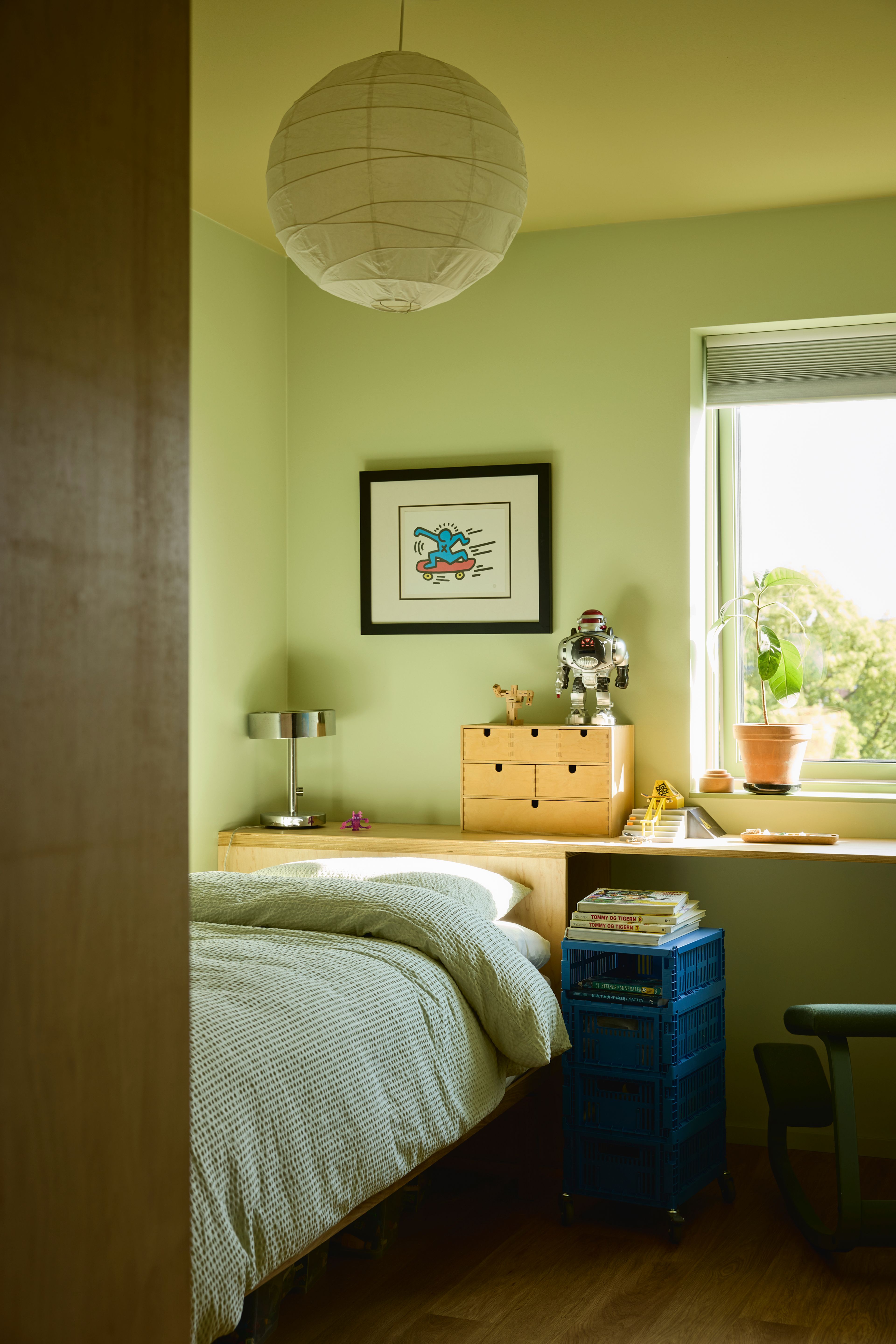 Et friskt grønt barnerom med praktiske oppbevaringsløsninger.