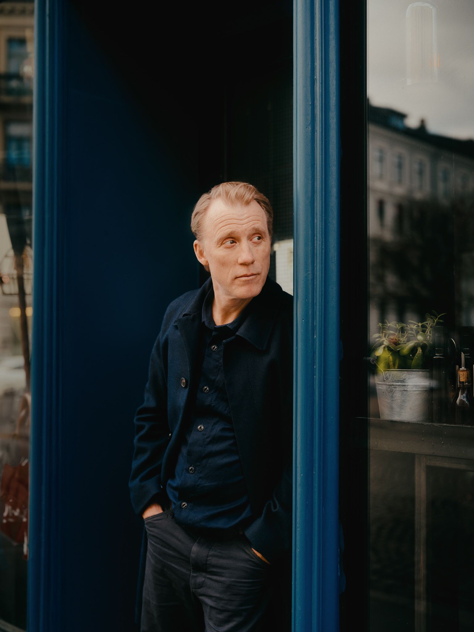 Thorbjørn Harr står lent inntil en dørkarm.