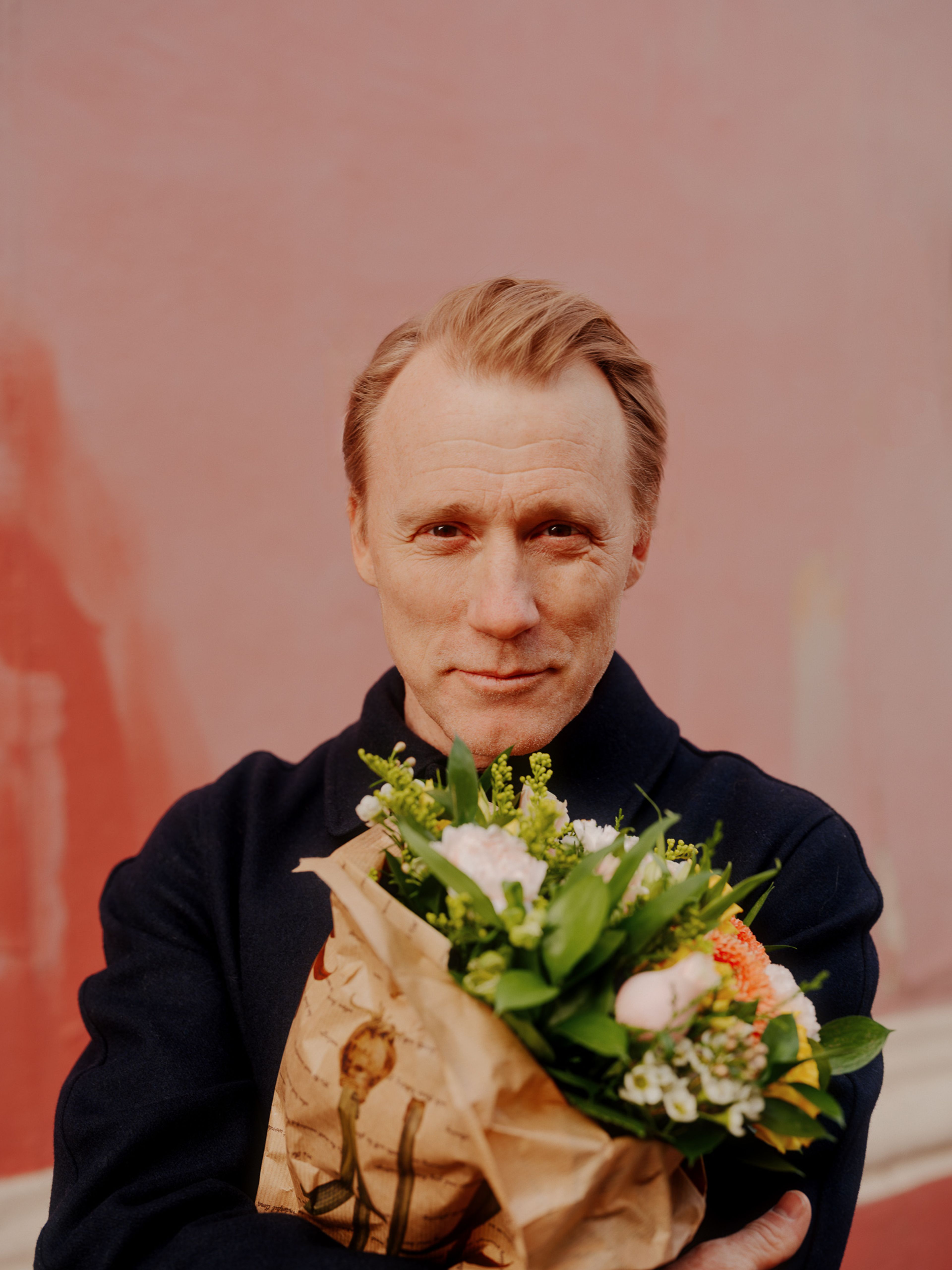 Thorbjørn Harr holder en blomsterbukett frem mot kameraet.