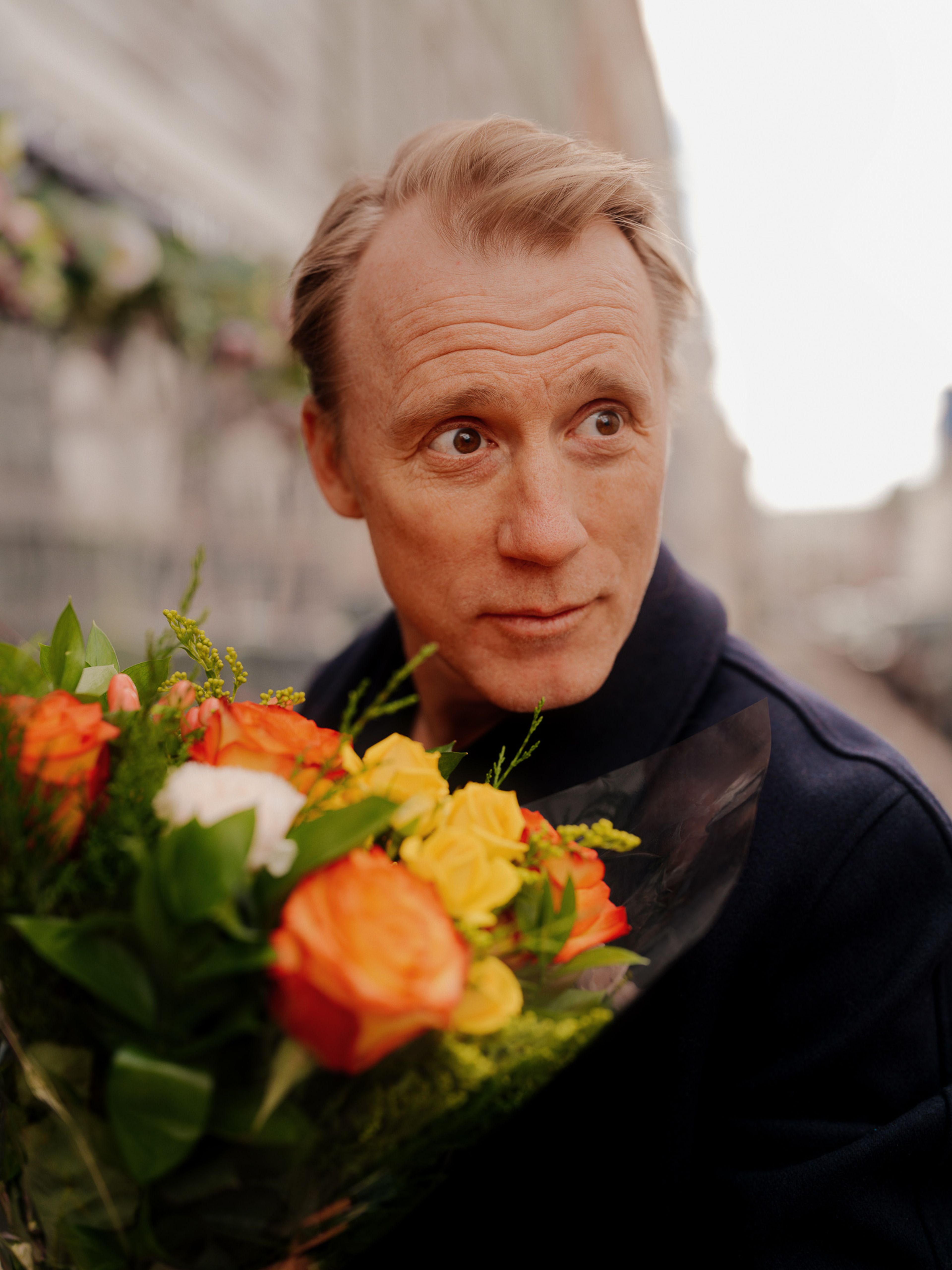 Thorbjørn Harr ser spørrende forbi kameraet mens han holder blomsterbuketten.