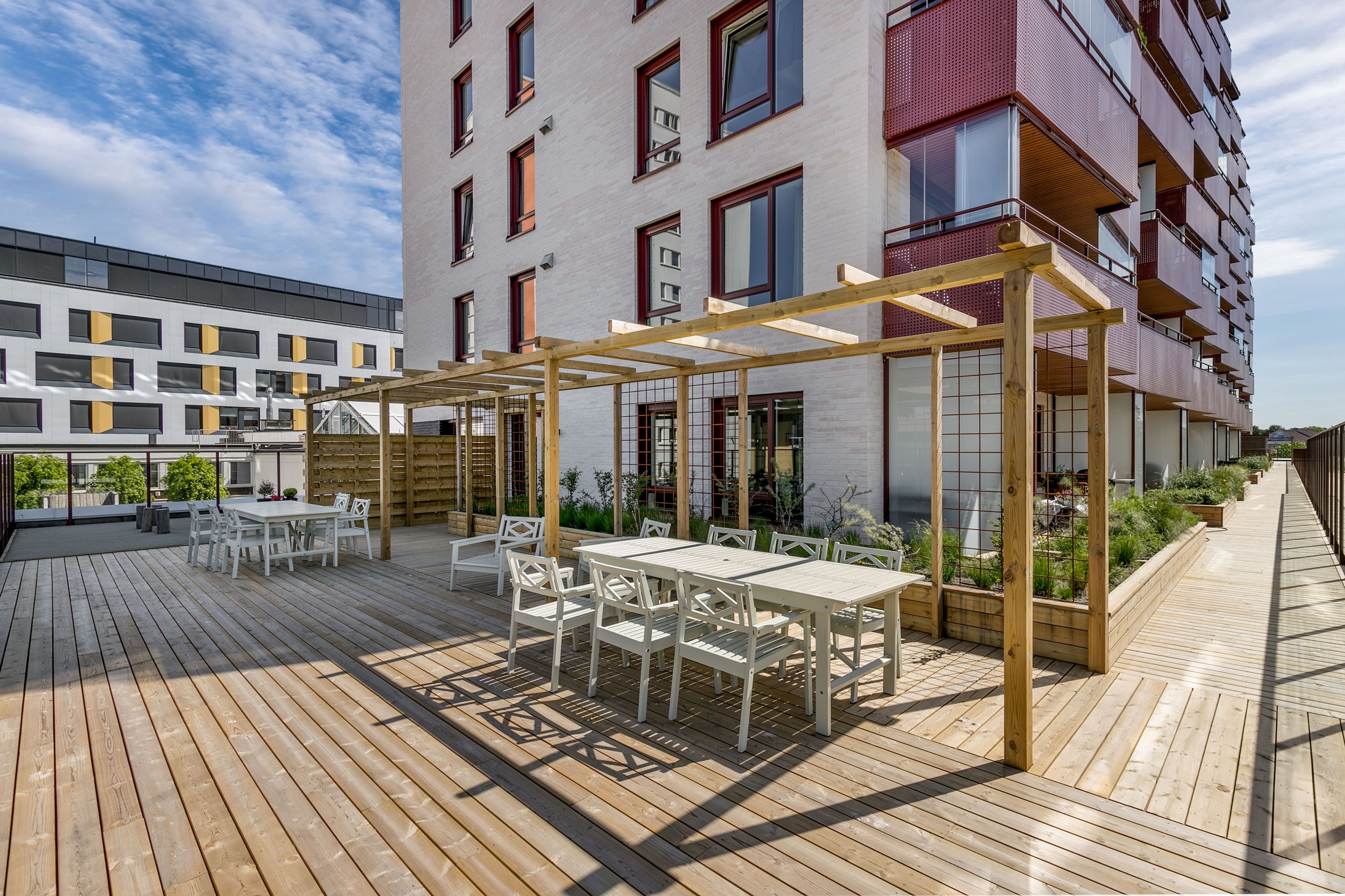Felles takterrasse med fokus på sitteplasser og pergola.
