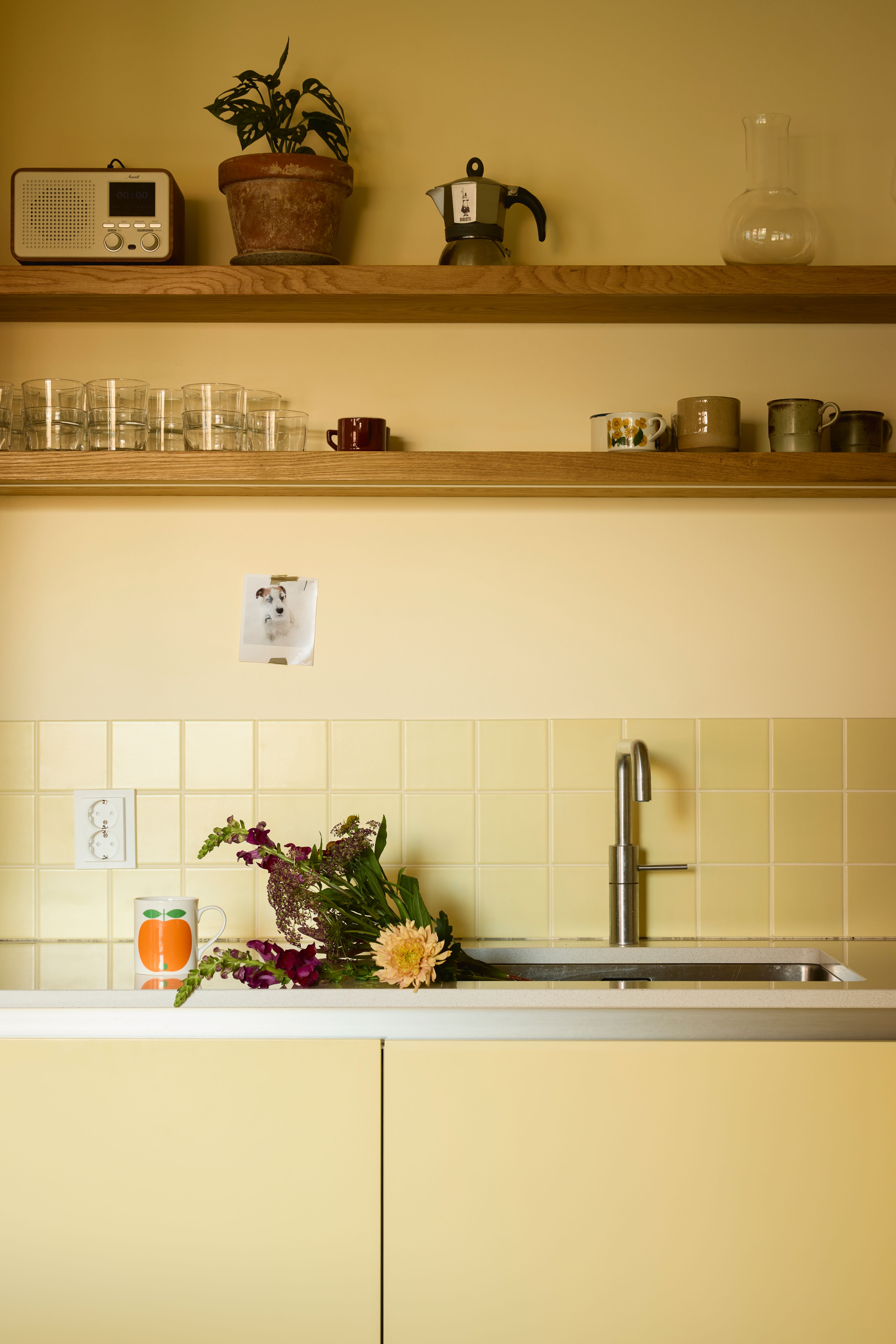 Et nærbilde av kjøkkenbenken med plassbygde hyller i eik.