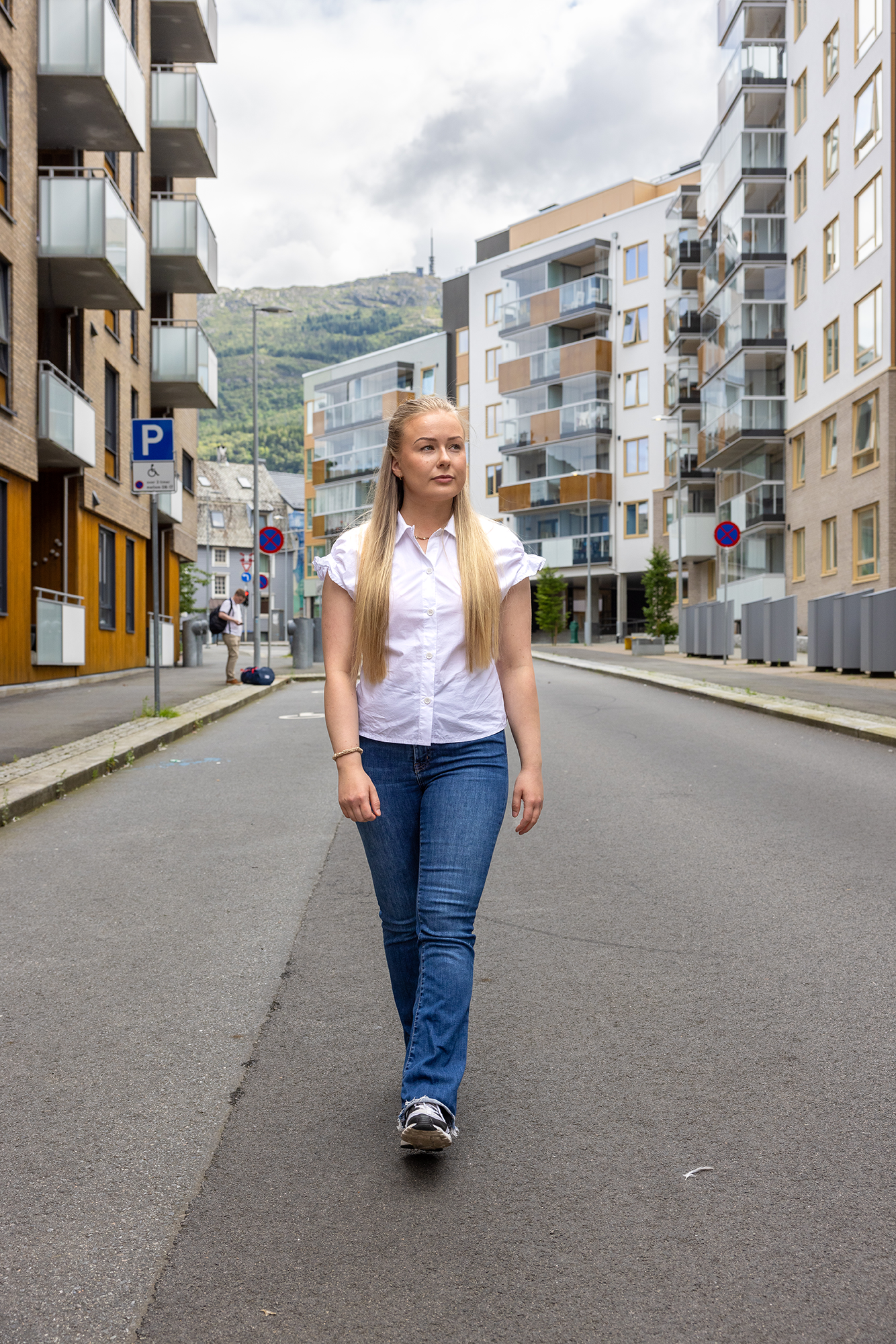 Amanda går langs en av gatene i Kronstadparken, med blokker synlig på hver side av veien.