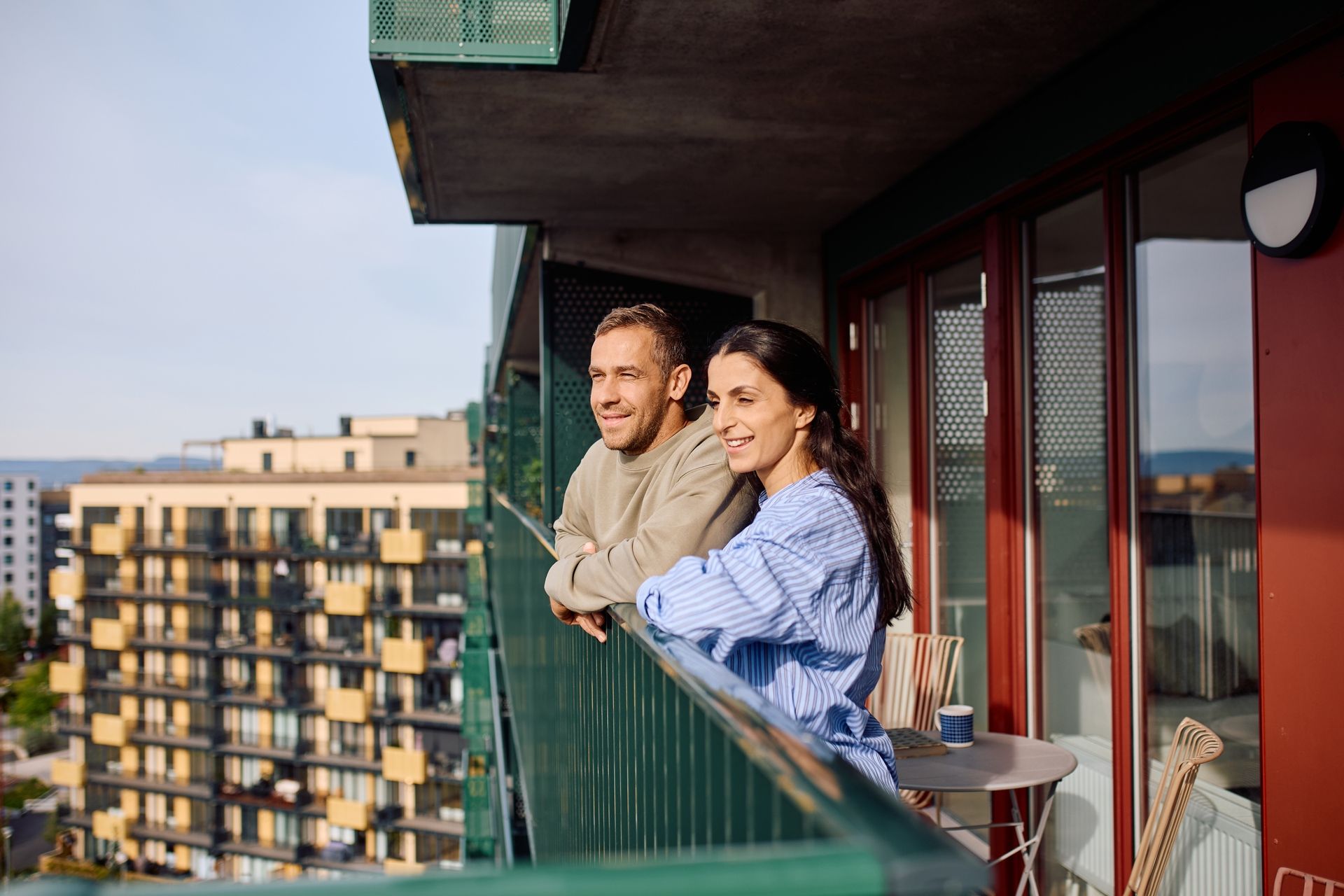 En mann og en kvinne skuer utover byen fra en balkong