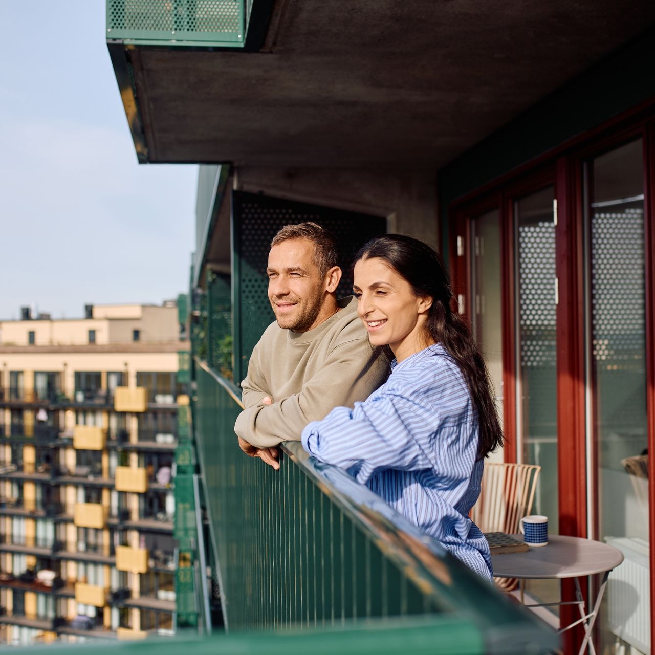 En mann og en kvinne skuer utover byen fra en balkong