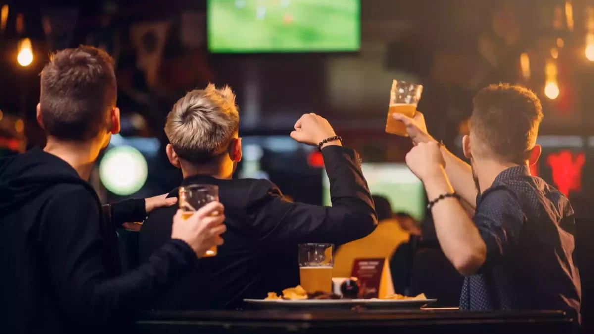 Sports fans watching live games on TVs in a bar