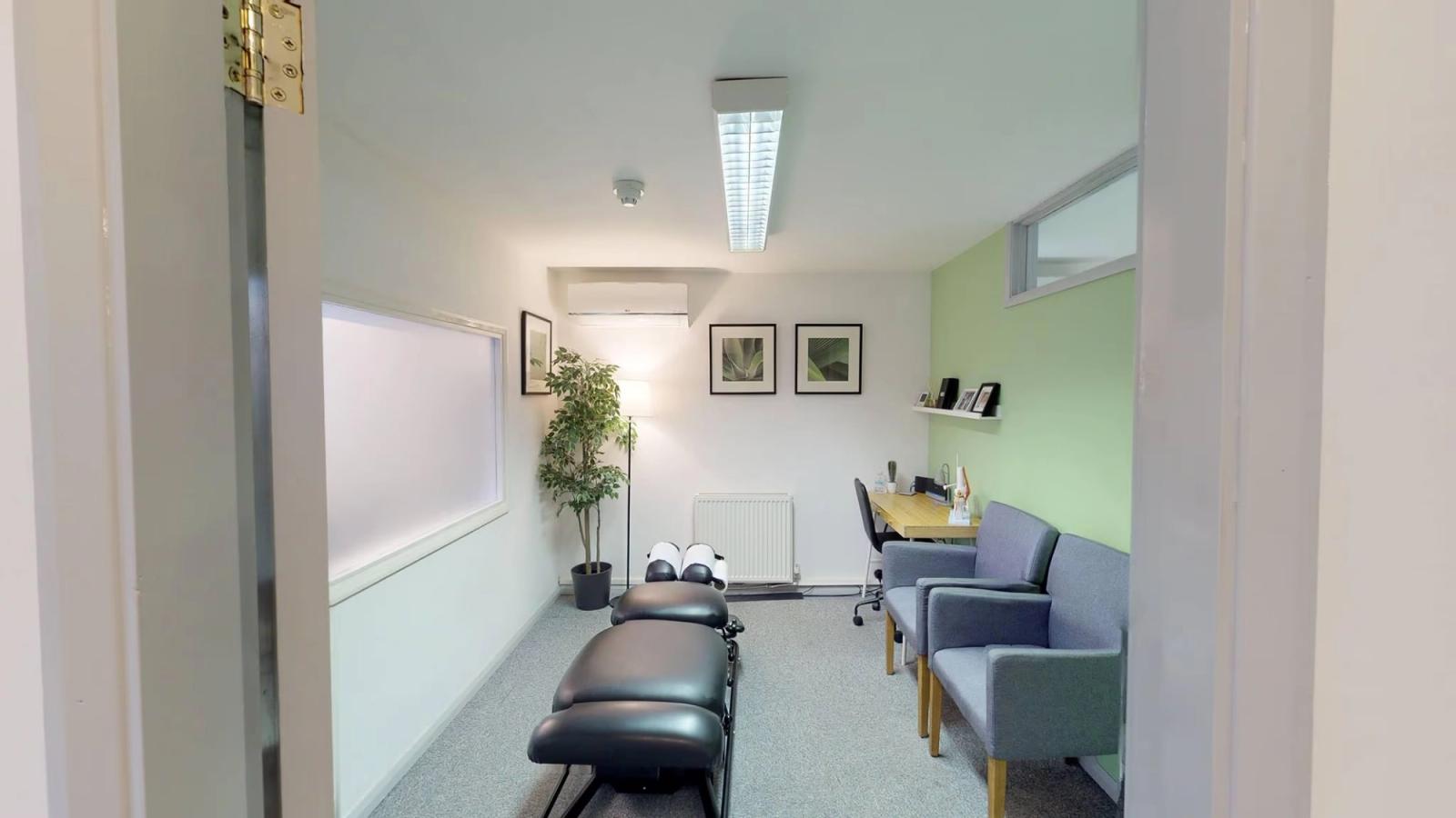 A treatment room at the Burton-on-Trent clinic, with an adjustment bench, desk and seating