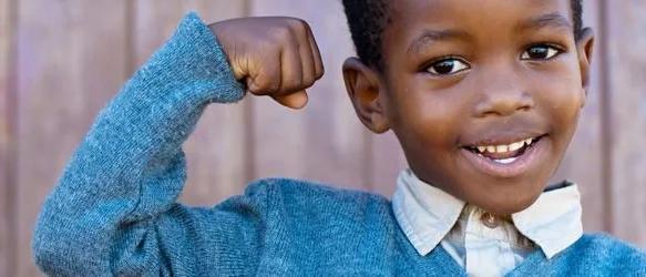 Smiling young boy flexing his arm