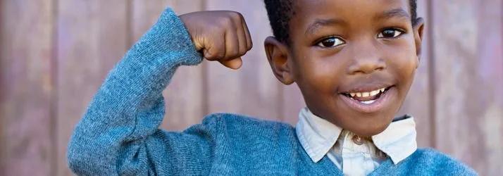 Smiling young boy flexing his arm