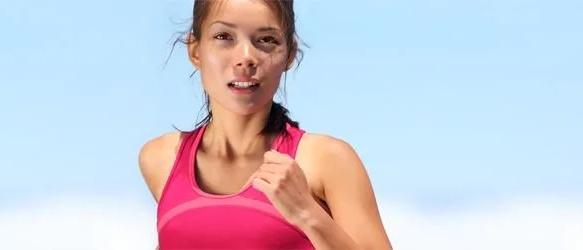 Woman in a pink sports top running outdoors