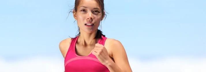 Woman in a pink sports top running outdoors