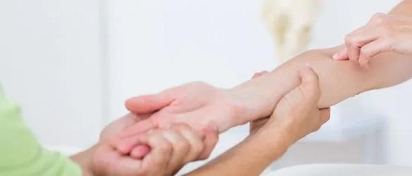 Practitioner holding and examining a patient's forearm and wrist