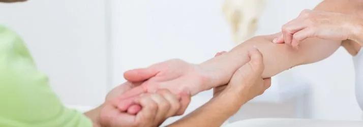 Practitioner holding and examining a patient's forearm and wrist
