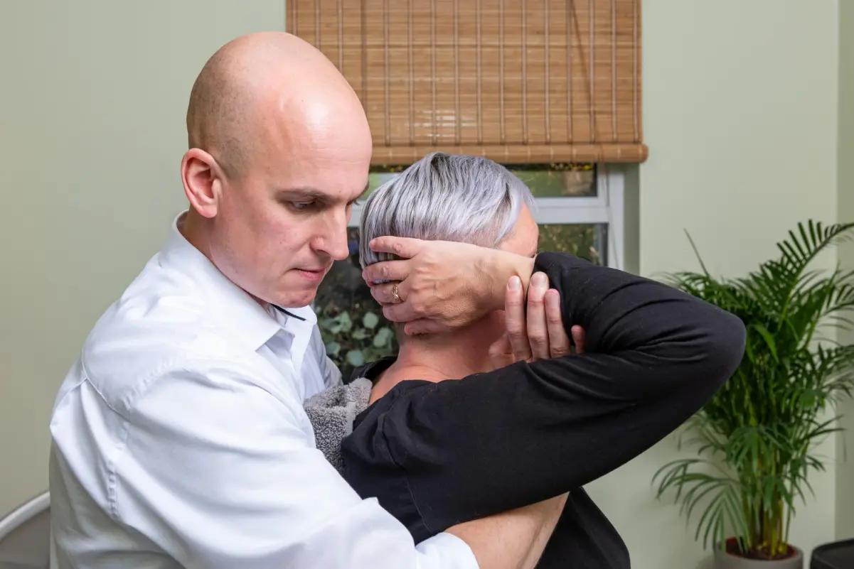 A chiropractor treating a patient’s neck at the clinic